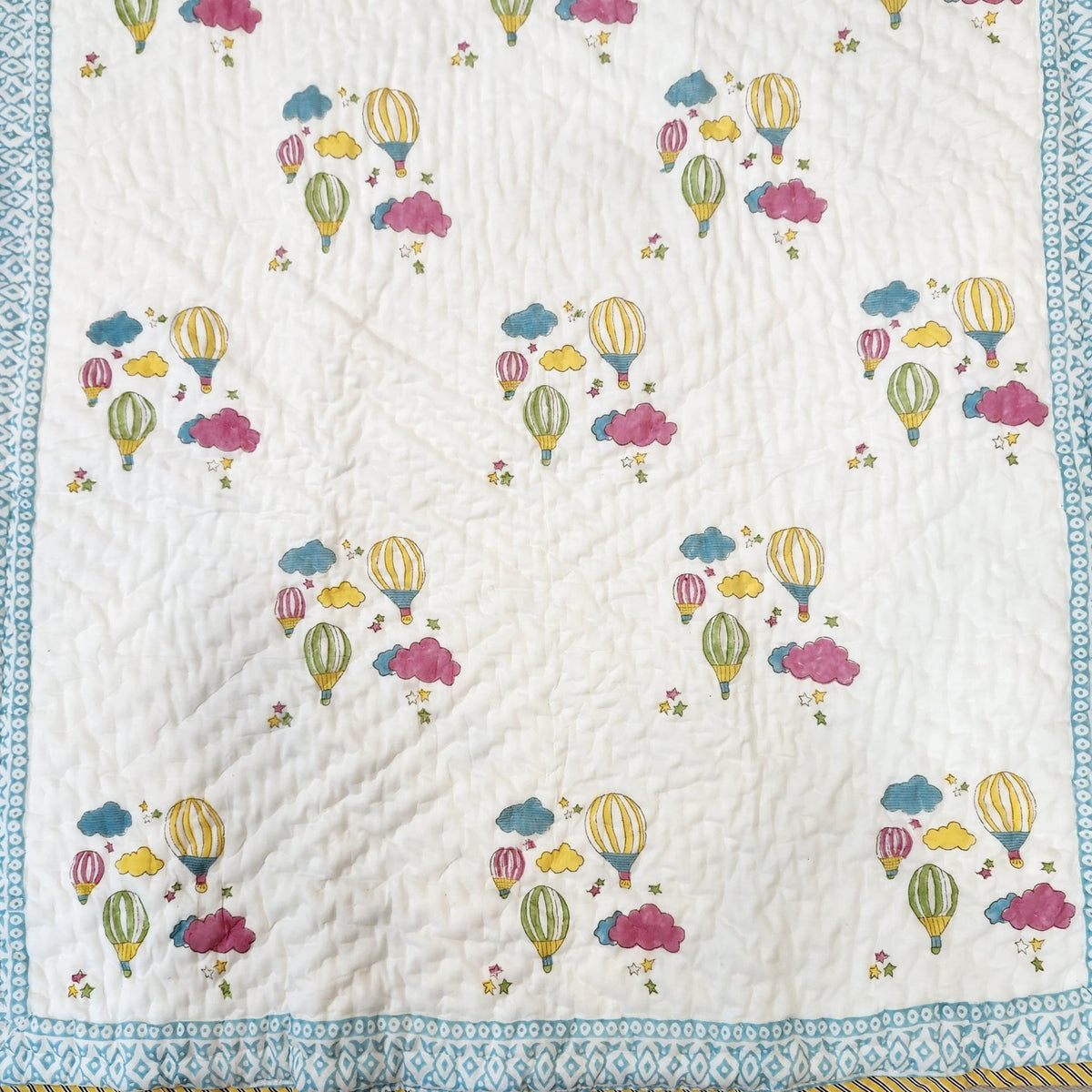 Child's block-print cotton quilt with a colourful balloon pattern, machine washable, 102 x 152 cm