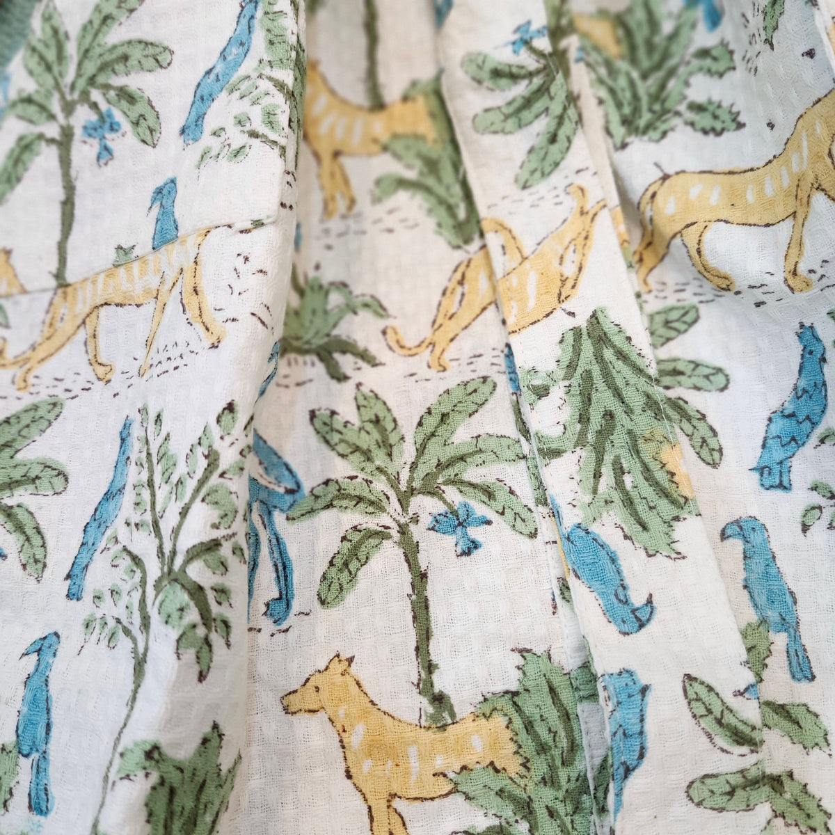 Detail of the jungle block print on a child's waffle bath robe, large cats, birds and trees, made with non-chemical dyes