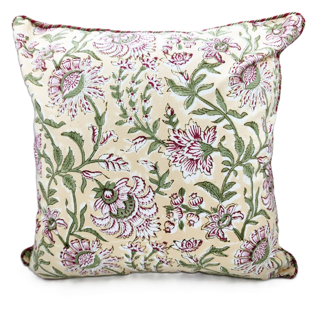 Styled view of the Summer block print cushion, pink flowers on a cream ground, pairing well with white bed linen or a sofa