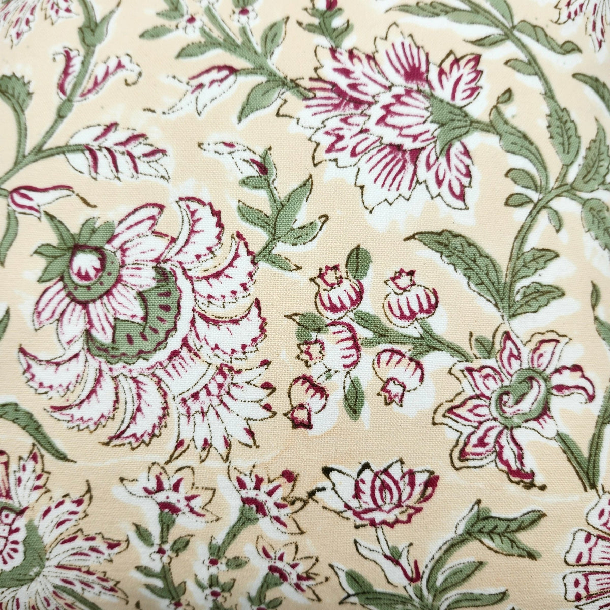 Detail of the deep pink flowers and green leaves on the Summer cushion cover, with the toning striped piping around its edge