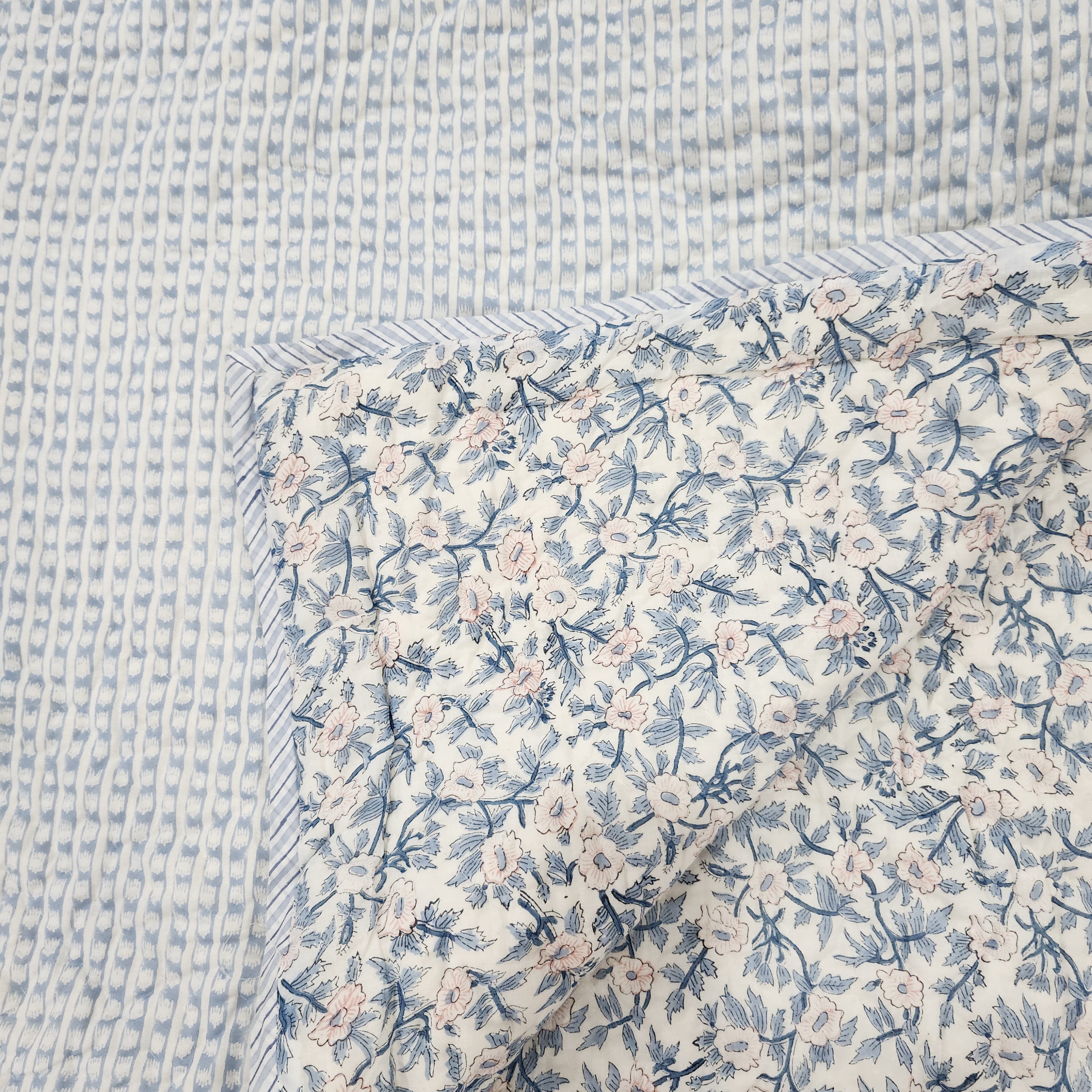 Single block-print quilt with a blue and white stripe on one side, reversible