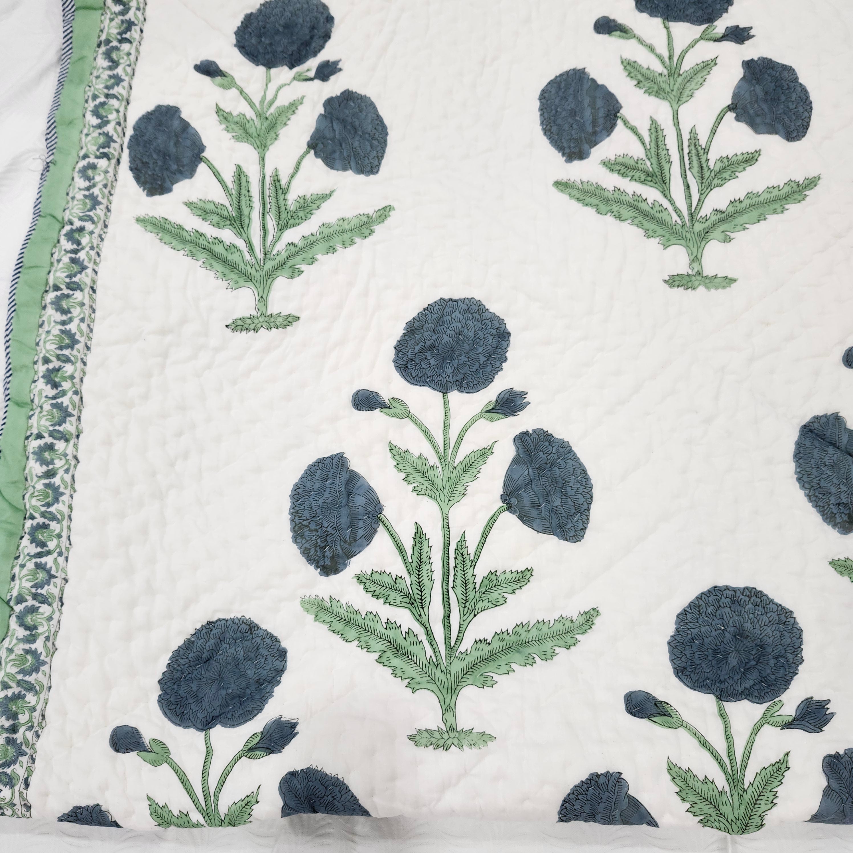 Large blue poppy block-print quilt in cotton, single size, styled on a bed