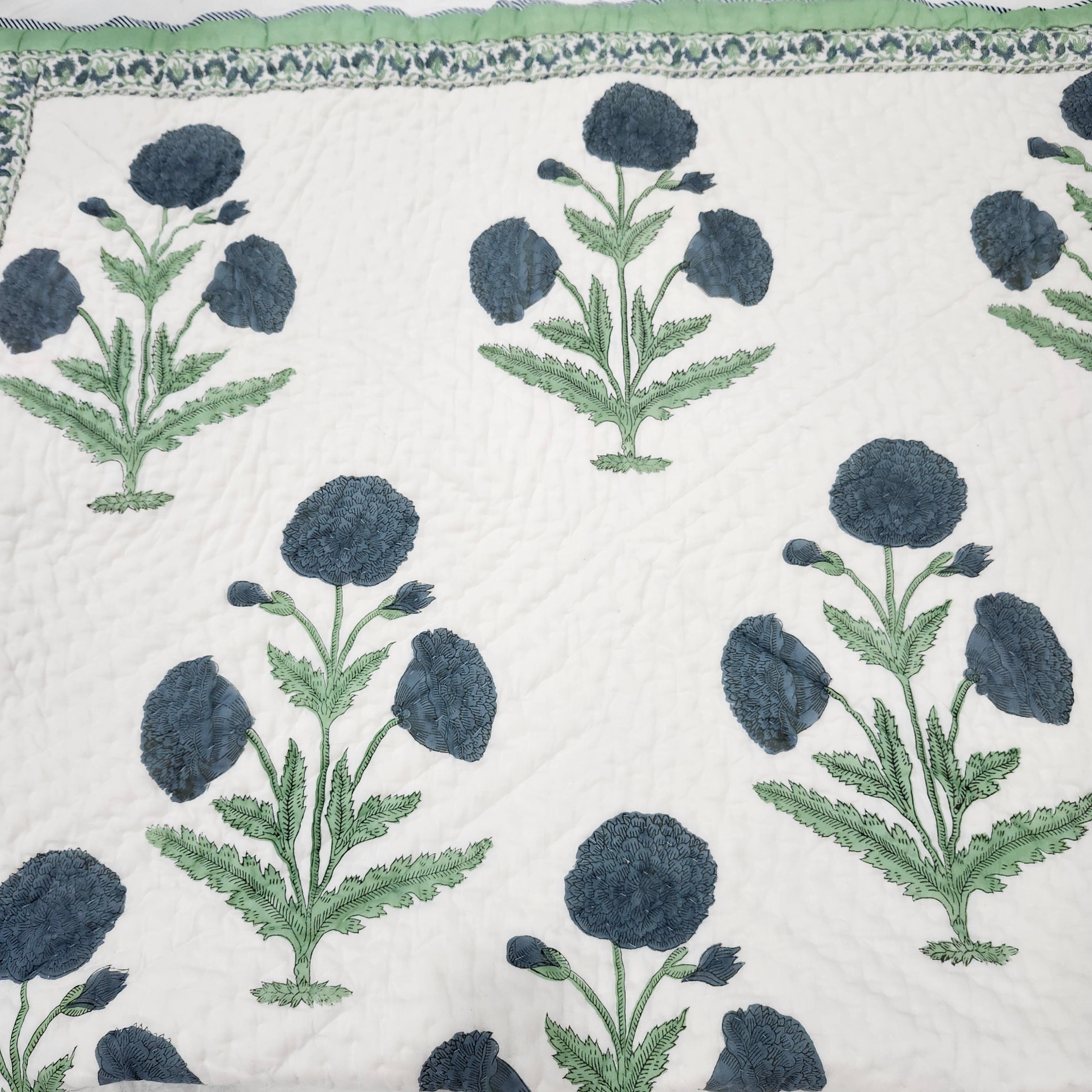 Blue poppy block-print single quilt with a blue and yellow floral print on the reverse