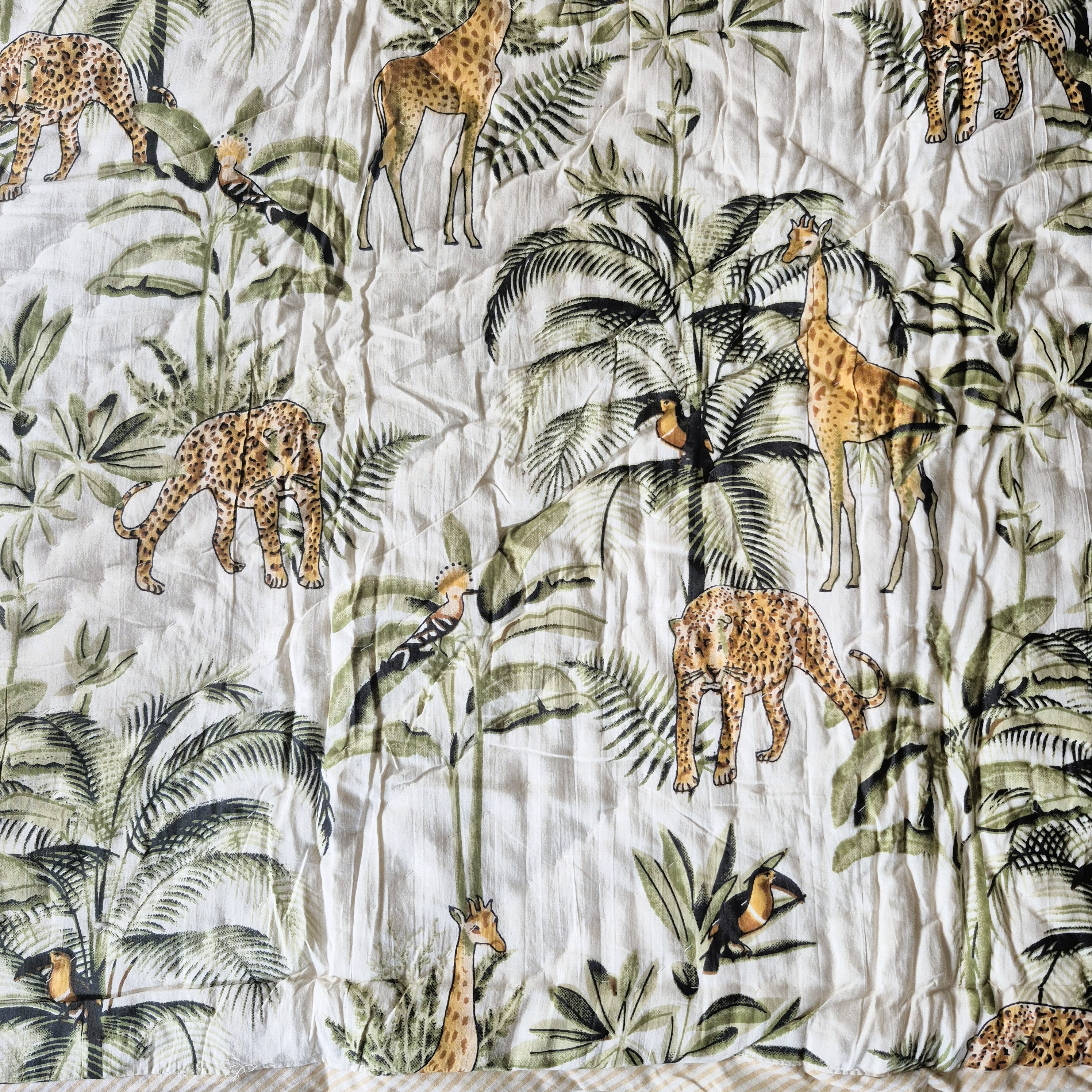 Reversible toddler quilt with block-print stripes on one side and a jungle animal print on the other, 110 x 150 cm