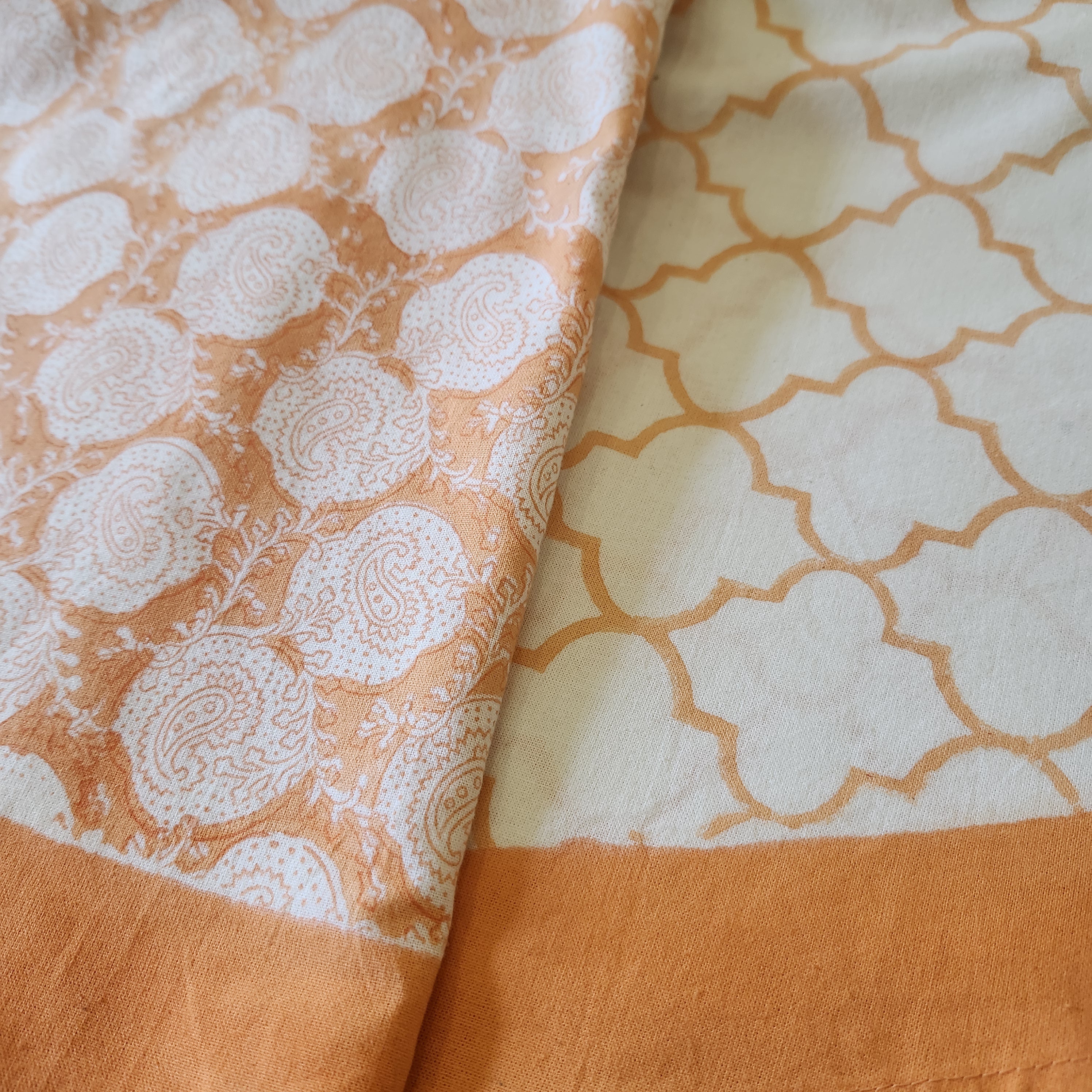 Round 225cm block print table cloth in orange/coral on white background
