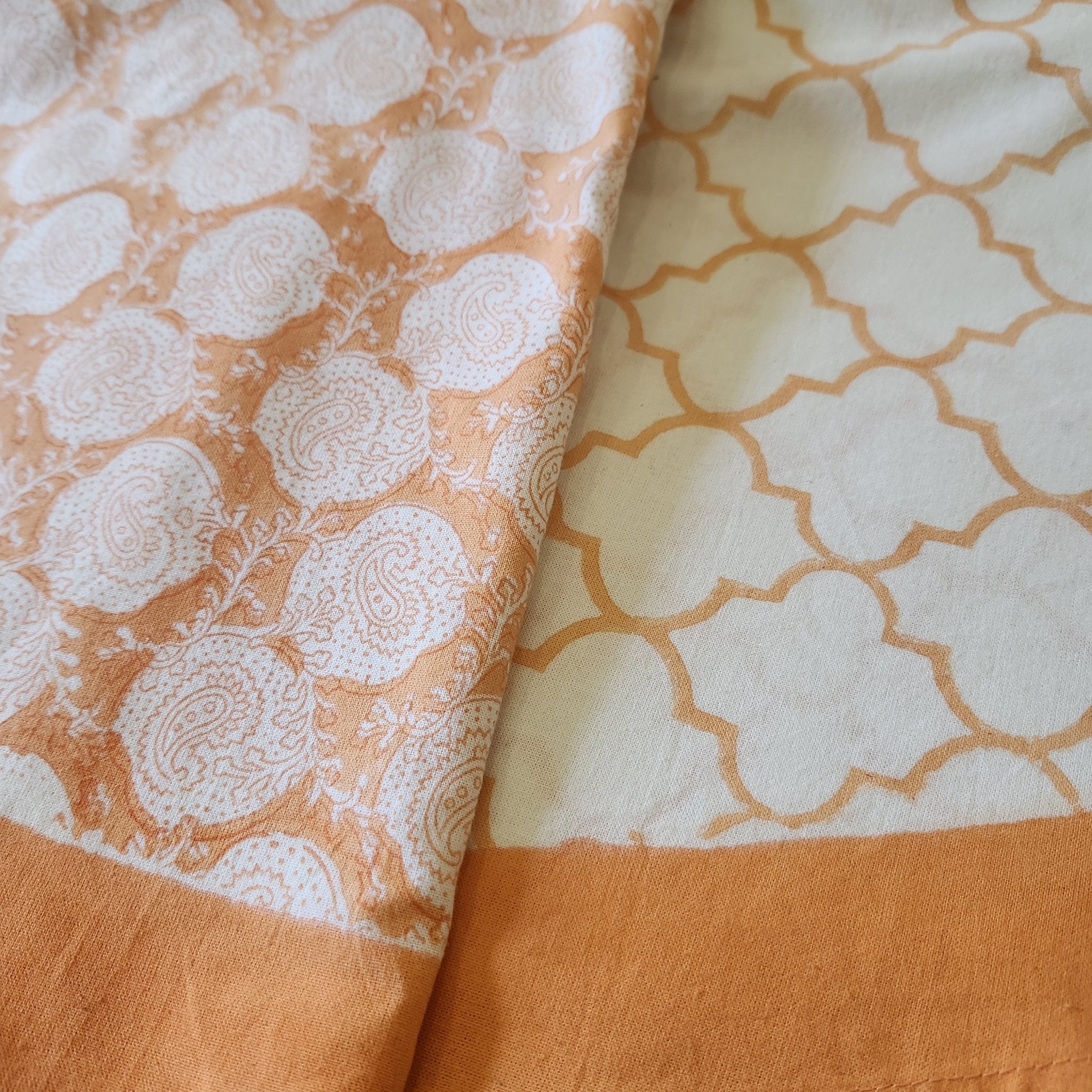 Round 225cm block print table cloth in orange/coral on white background