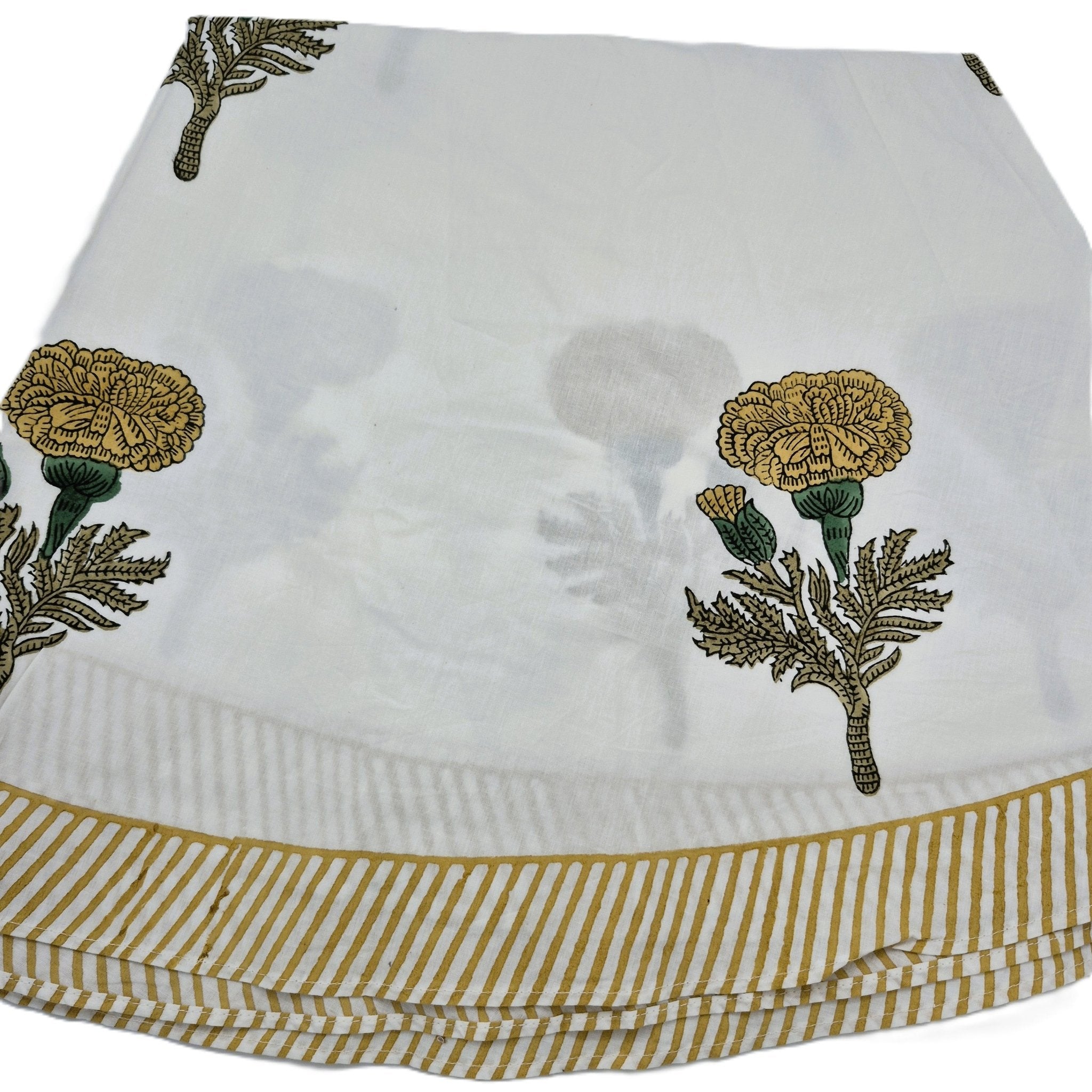 A round block printed poppy tablecloth with mustard yellow flowers and striped border