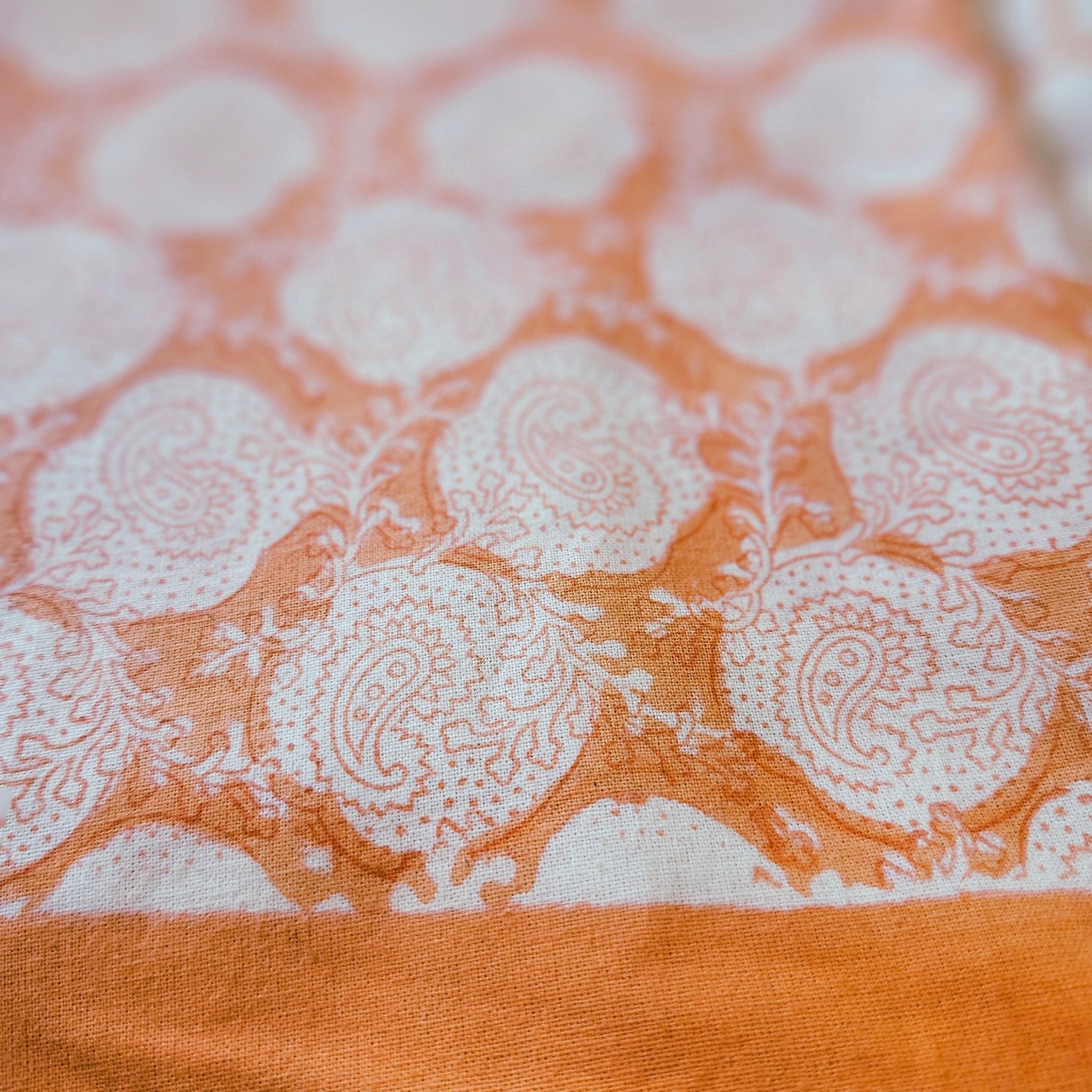 Round coral paisley block-print cotton tablecloth, 225 cm diameter, on white
