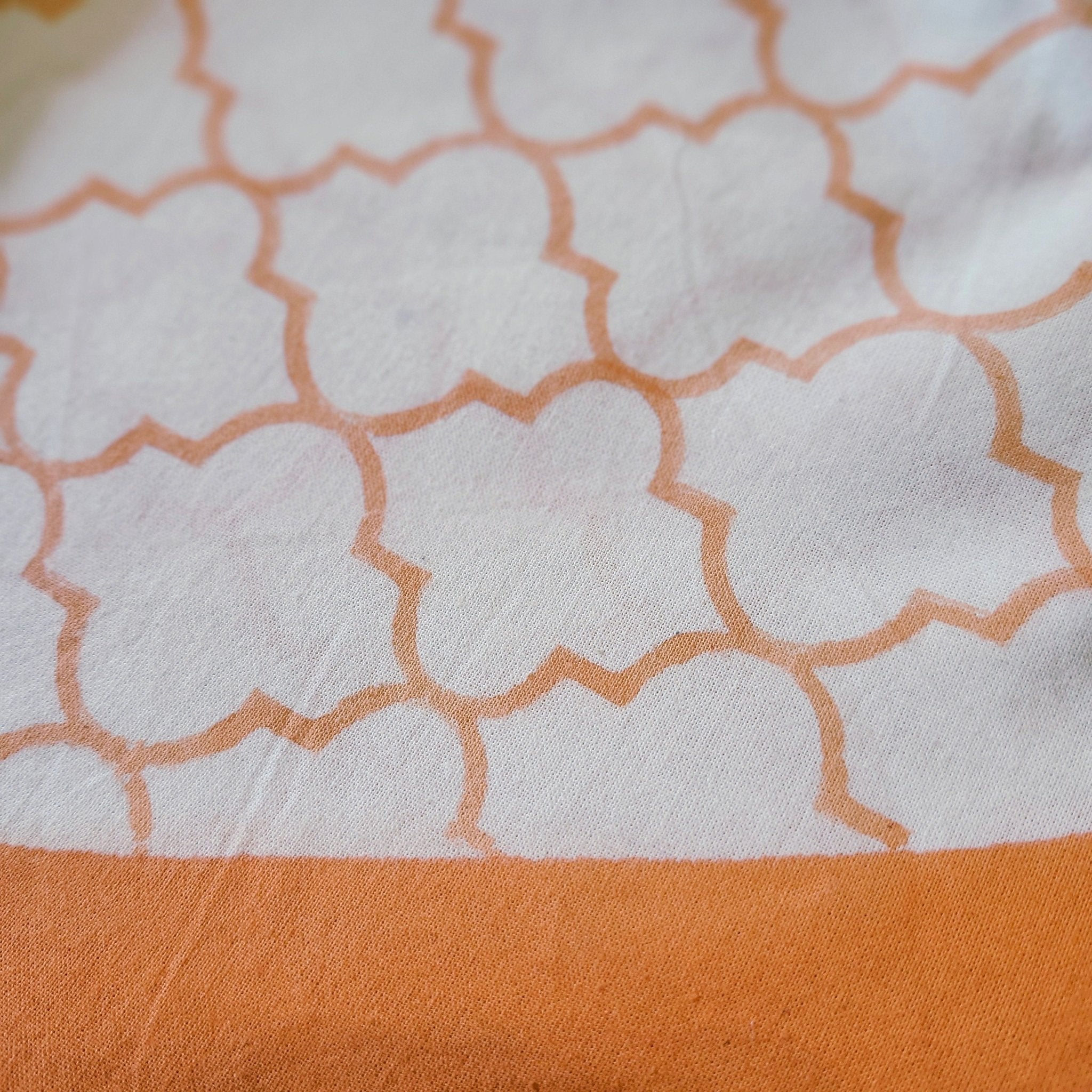 Round coral trellis block-print cotton tablecloth, 225 cm diameter, on white