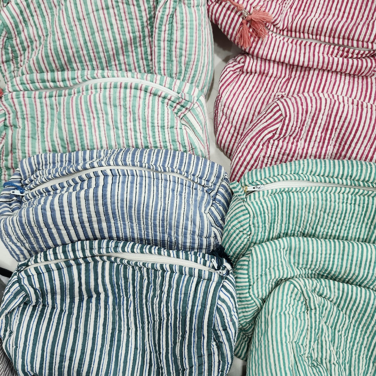 Handmade wash bag with slim block printed stripes in a variety of colours on white, a tassel, zip and four inner pockets