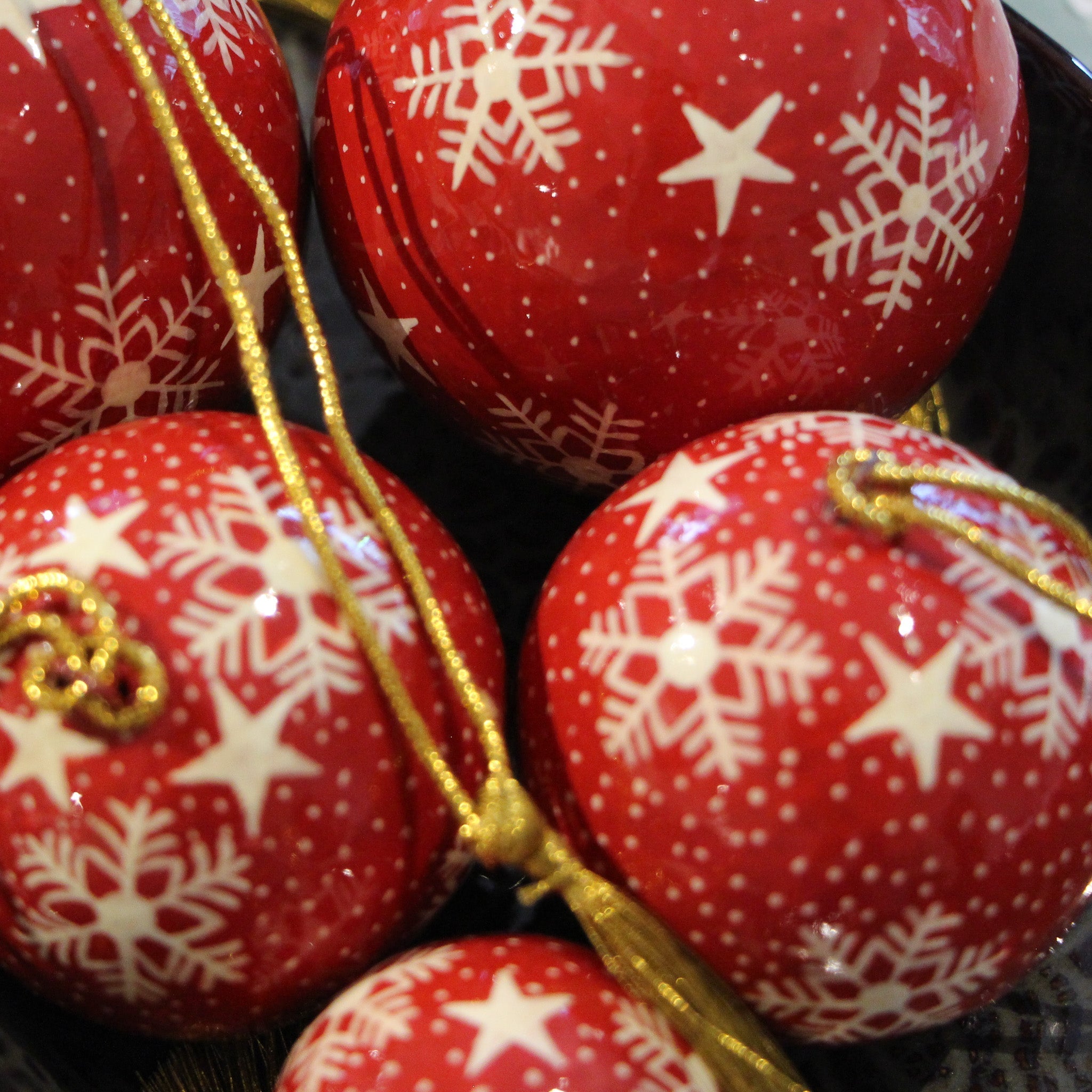 Red papier-mache Christmas bauble hand-painted with a snowflake design