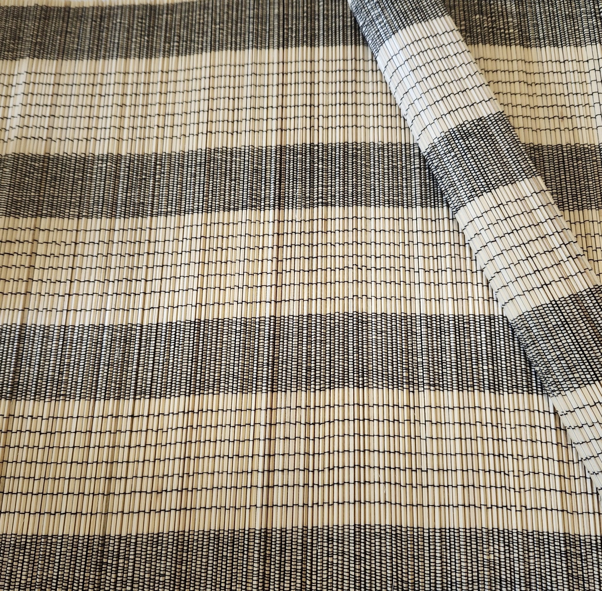 A natural bamboo placemat or table mat with black thread