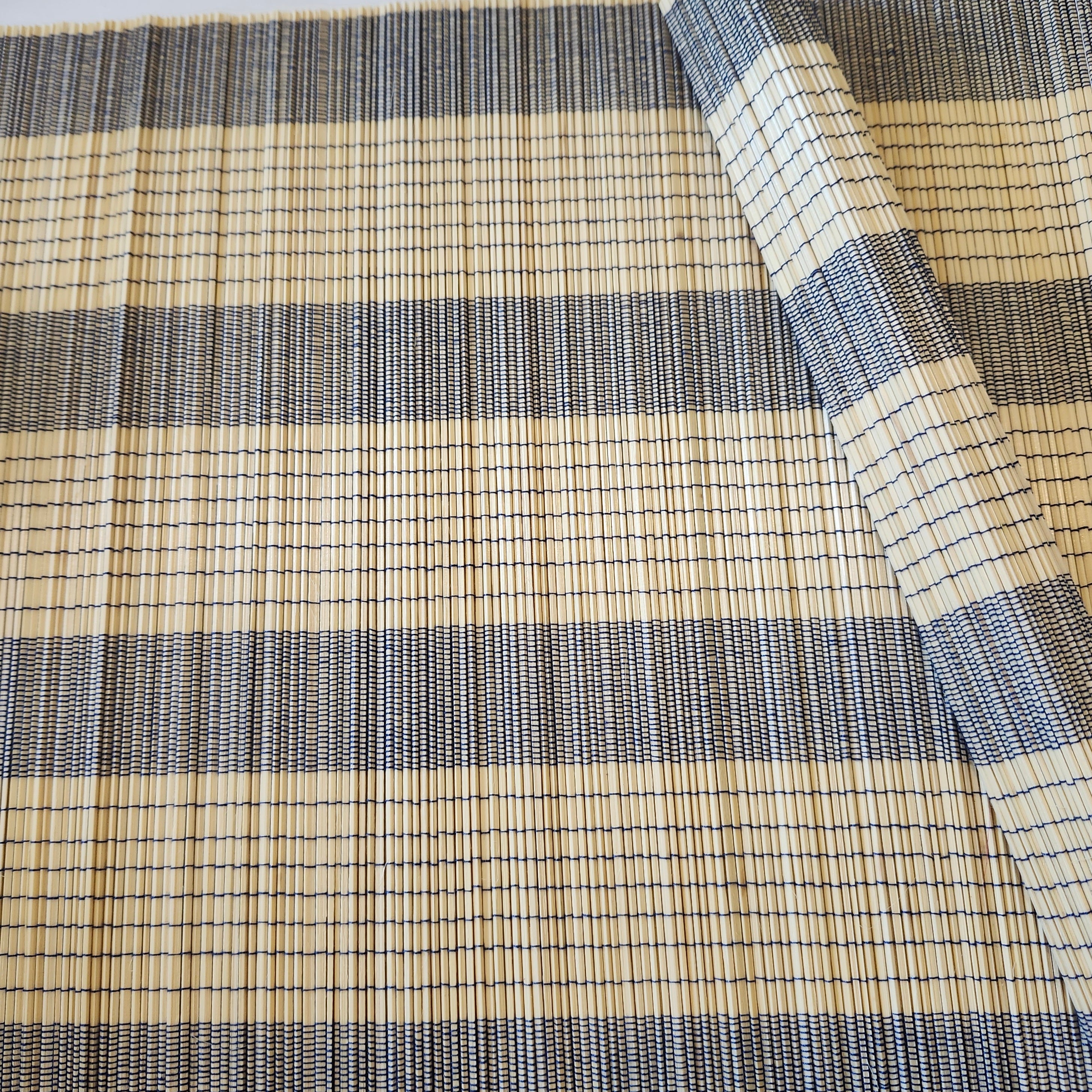 A natural bamboo placemat or table mat with navy blue stripes