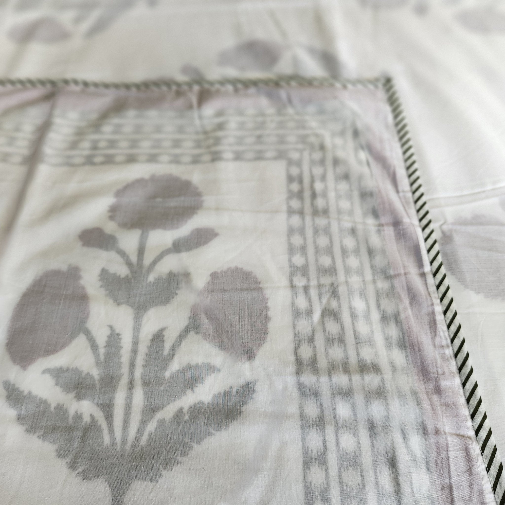 A soft cotton block print dohar or lightweight blanket with a poppy print in red on a white background