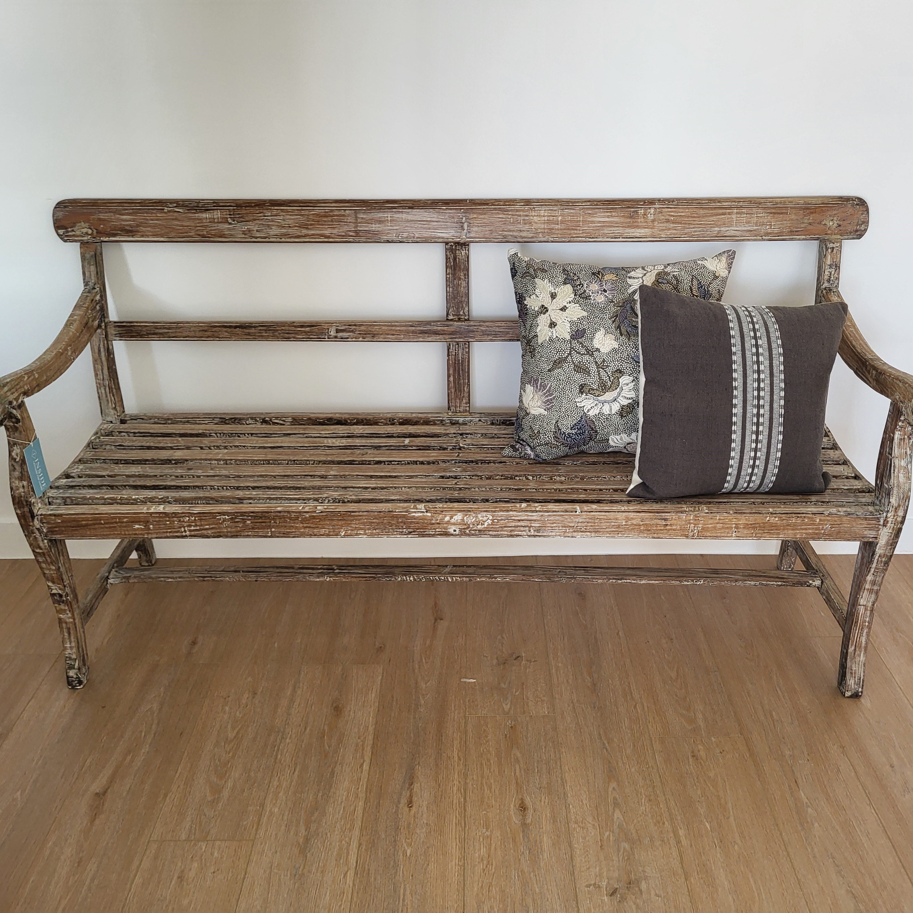 Vintage teak bench with cushions and throws, styled