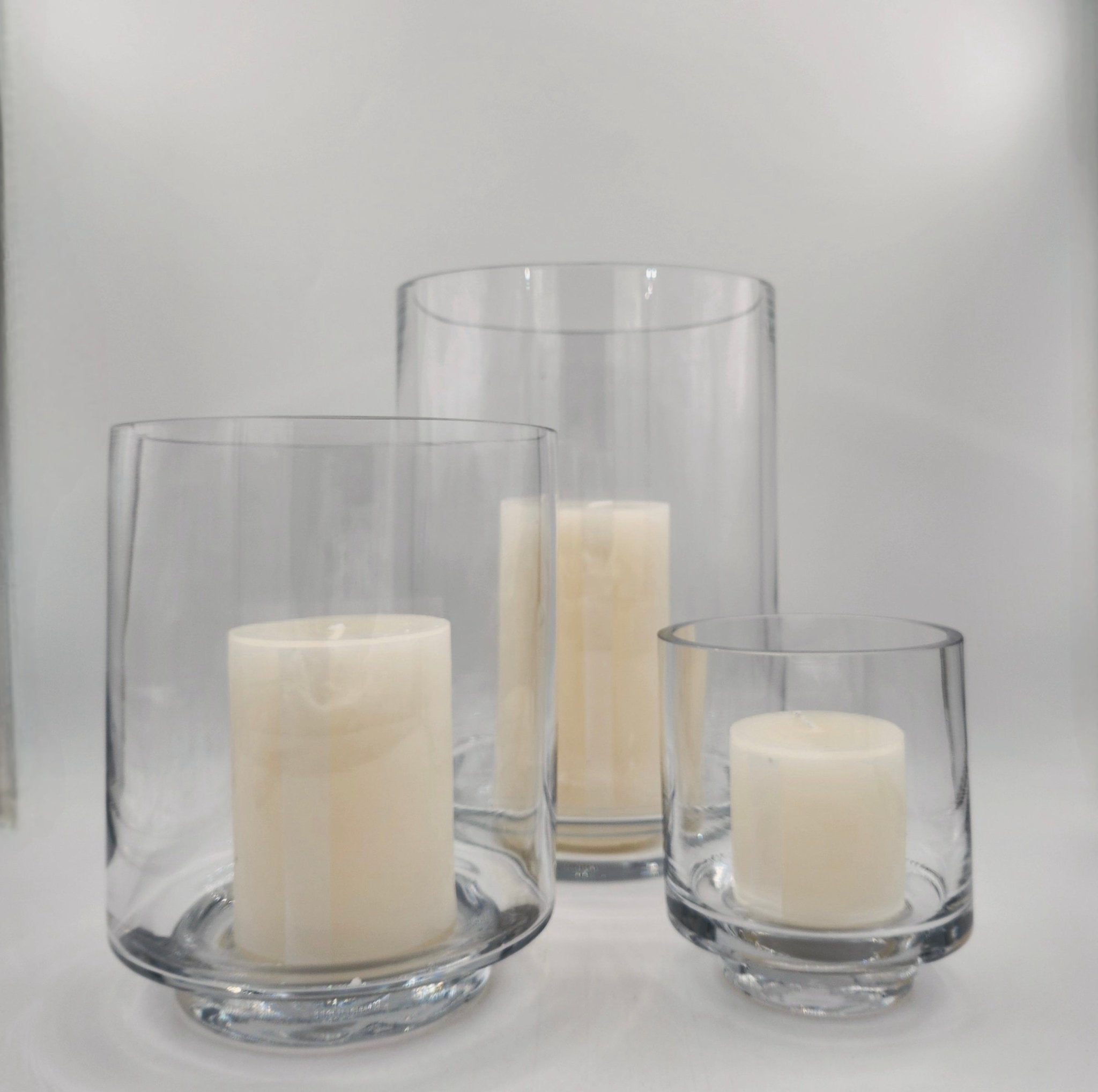 Glass hurricane lamps with round bases, set of three, candles included