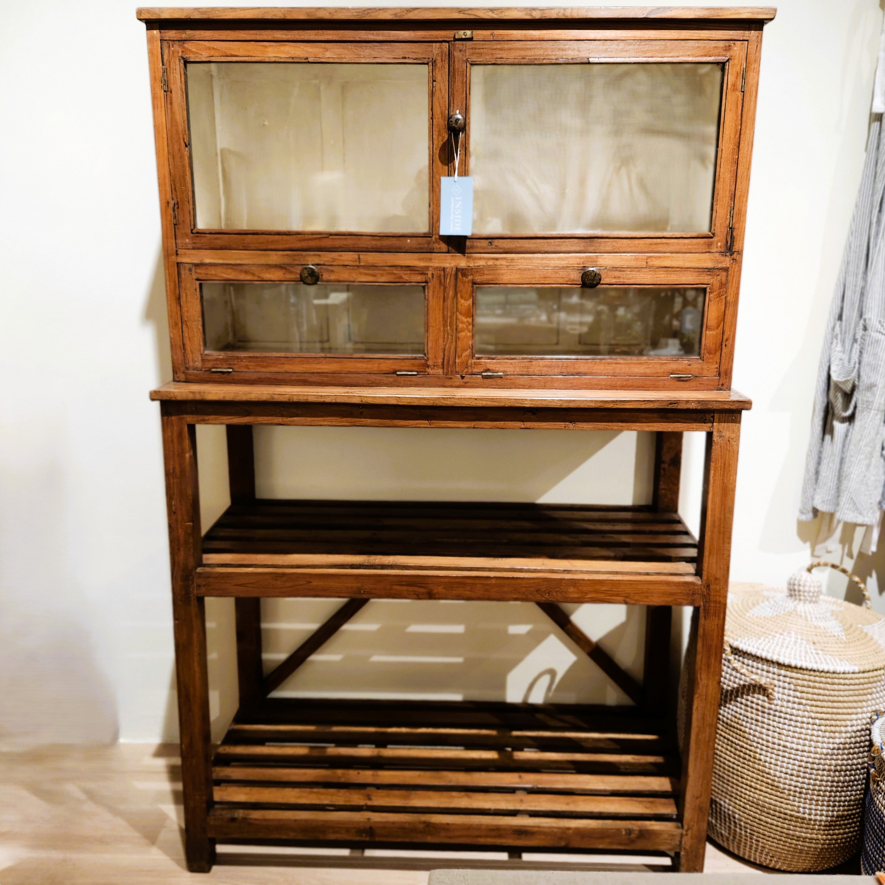 Teak glass-door cabinet with cream interior, styled