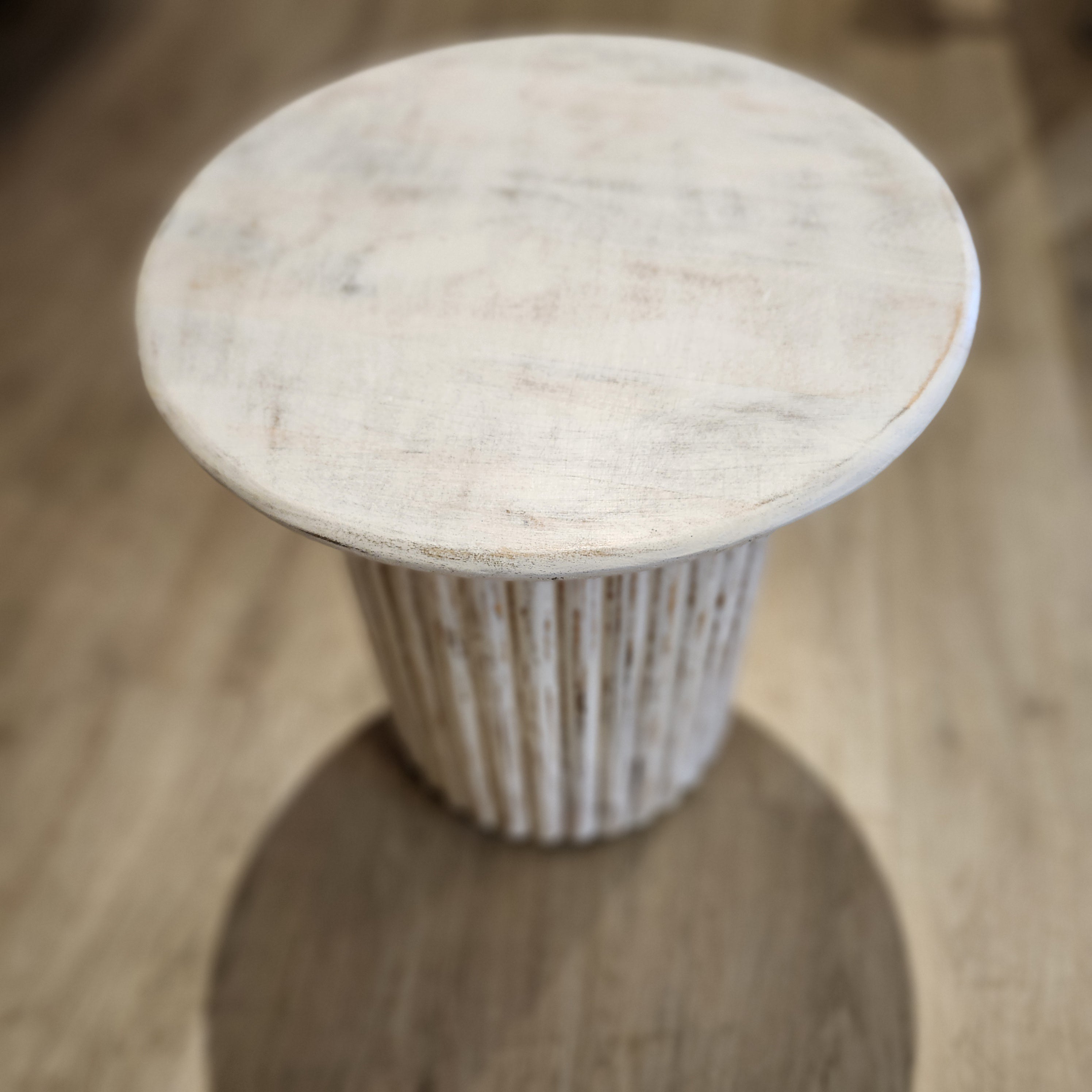 Round mango wood side table with fluted pedestal in a limed finish, made in India