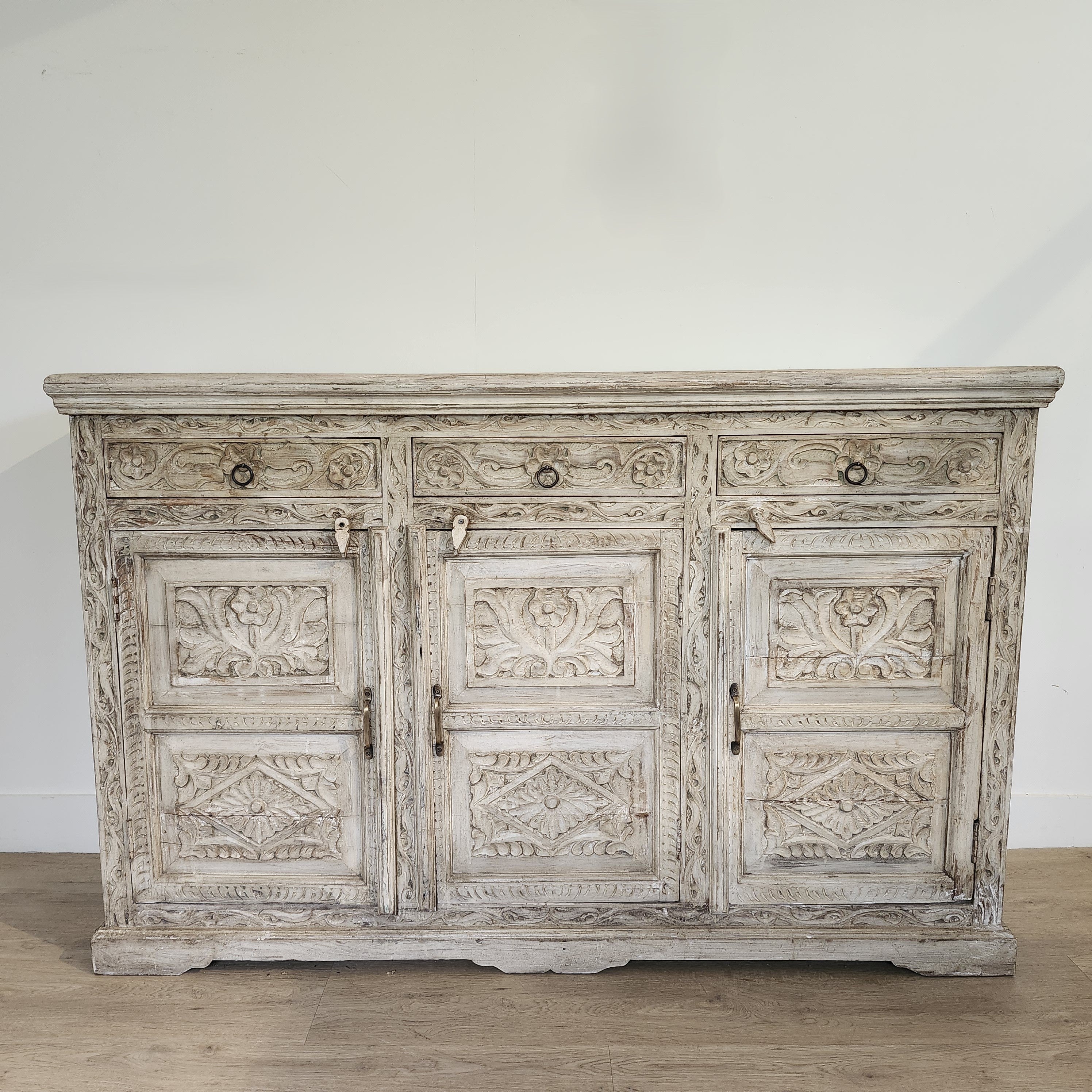 Hand-carved mango wood sideboard with three drawers and a limed finish