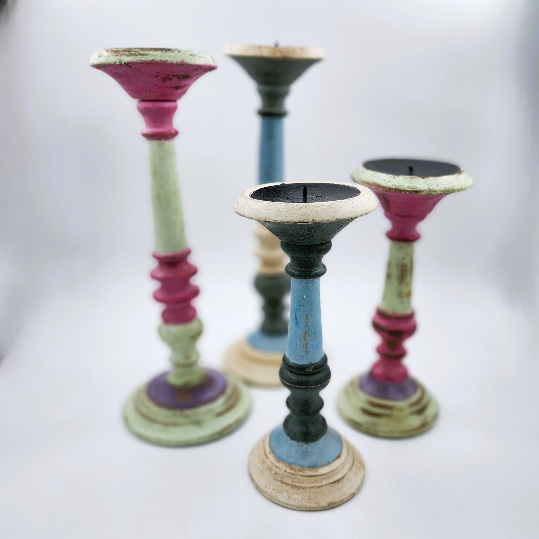 Painted wood candle stands in matte pastel colours, rustic Rajasthan style