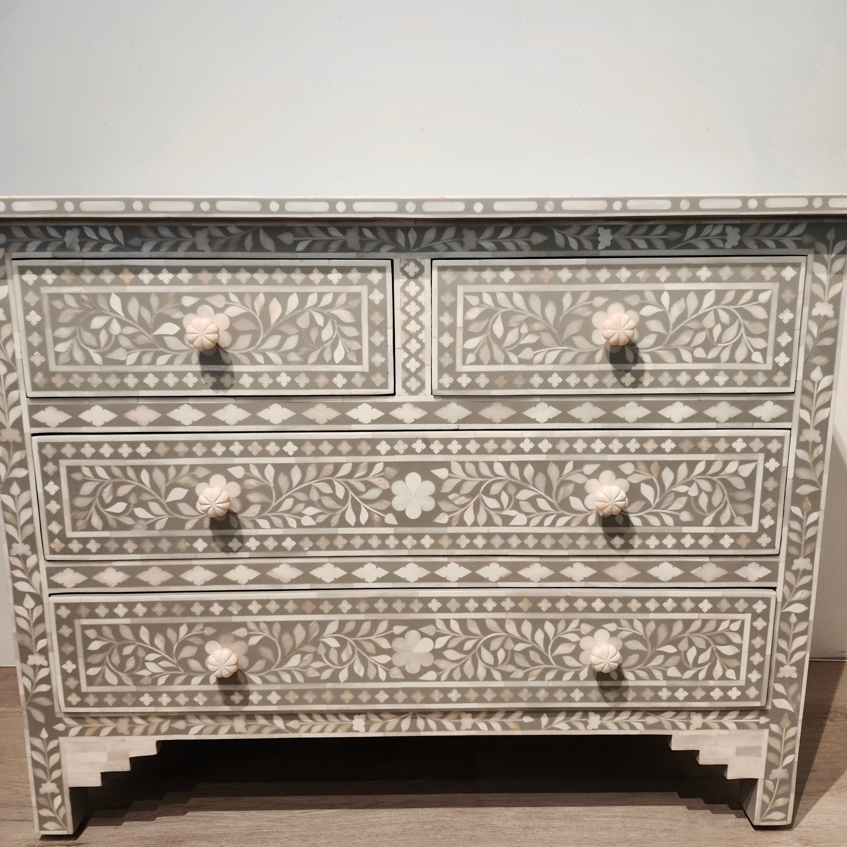 Bone inlay chest of drawers in taupe with a carved leaf design