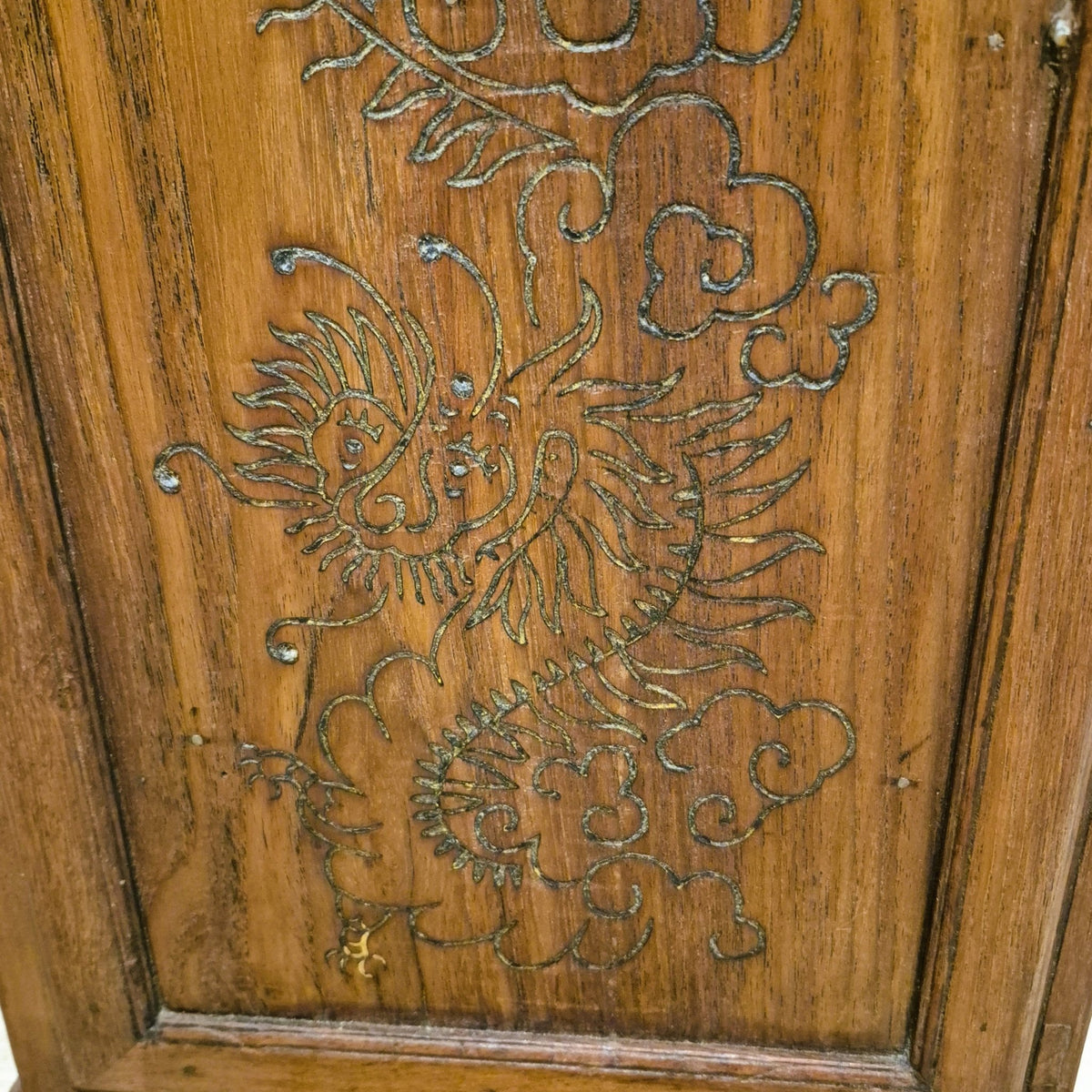 Carved dragon detail on a small vintage teak side table, with a shelf inside the cupboard underneath