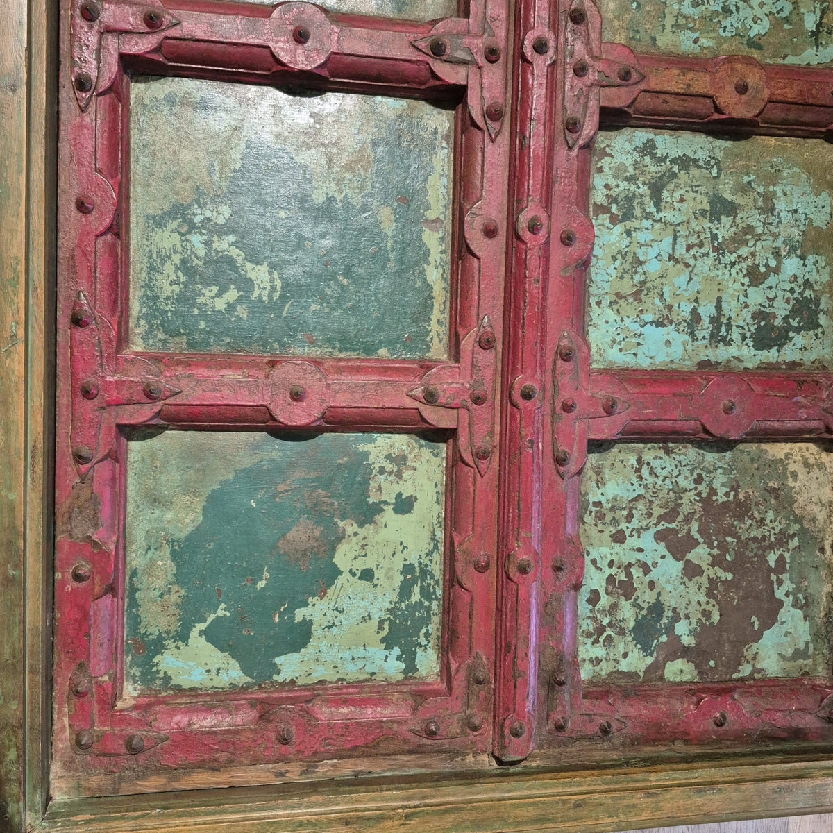 Vintage door coffee table from India, an old painted teak door on four carved legs beneath glass, 177cm wide and 45cm high
