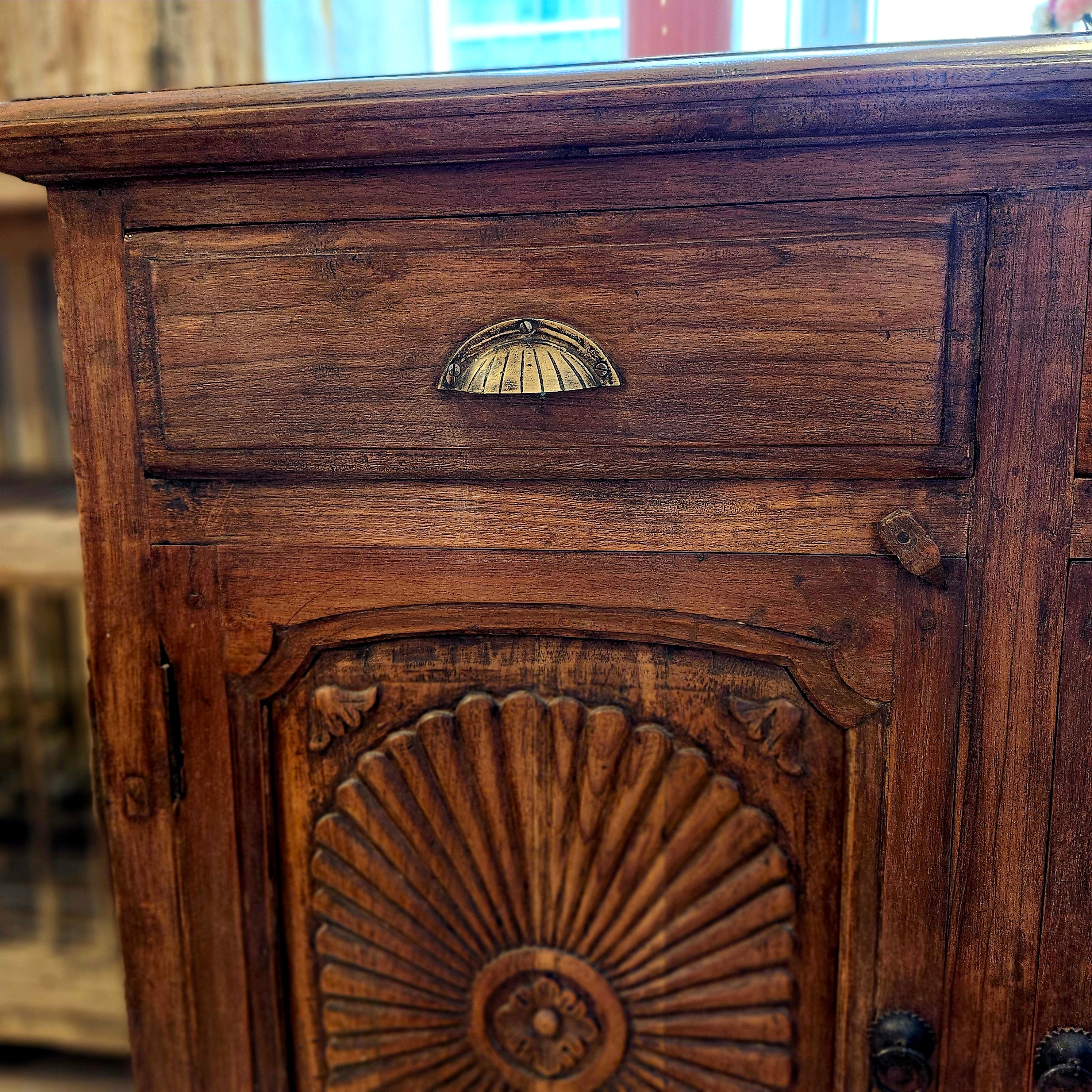 Teak sideboard with brass handles, carved doors, styled