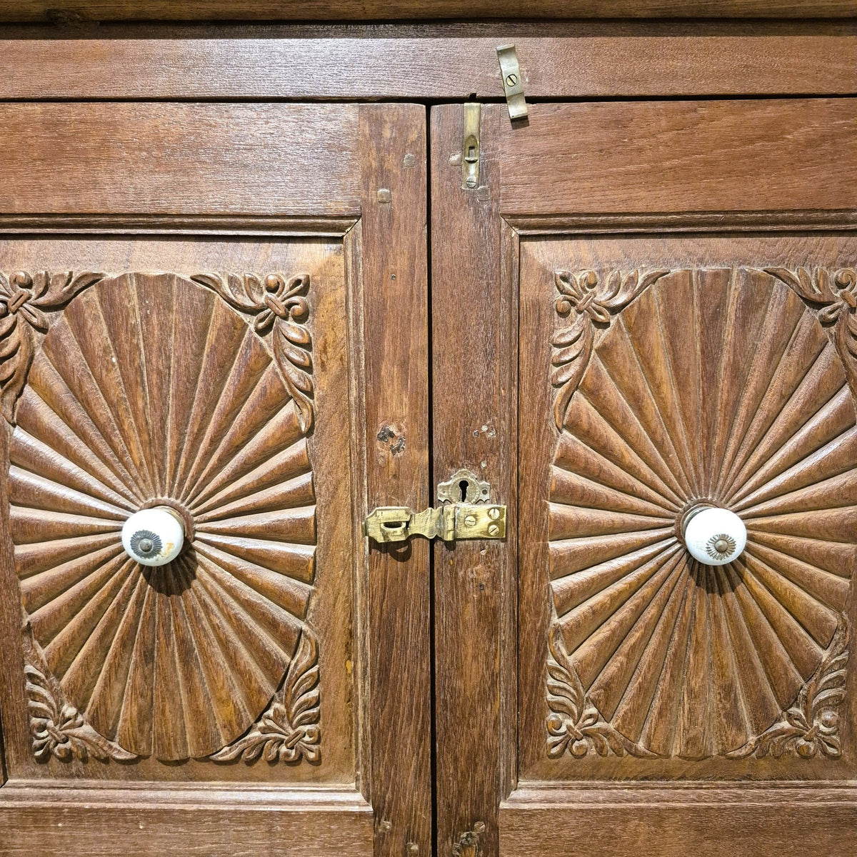 Teak sunburst cabinet with ceramic knobs and two brass handled drawers at the base, 59 cm deep, India