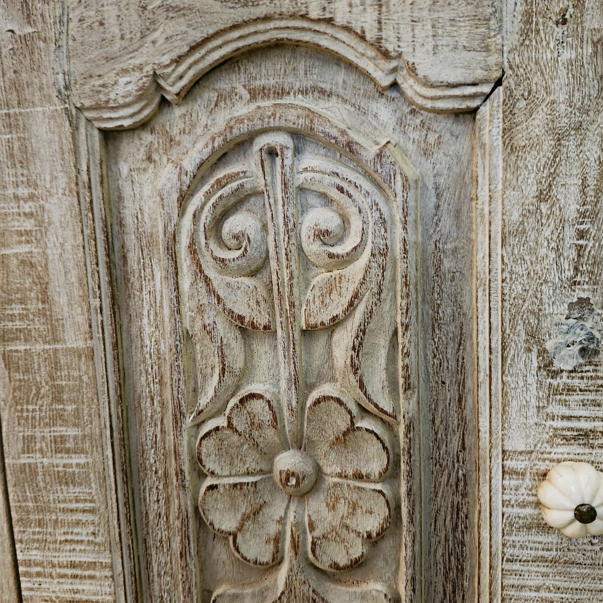 Whitewashed teak bedside cabinet, carved door detail