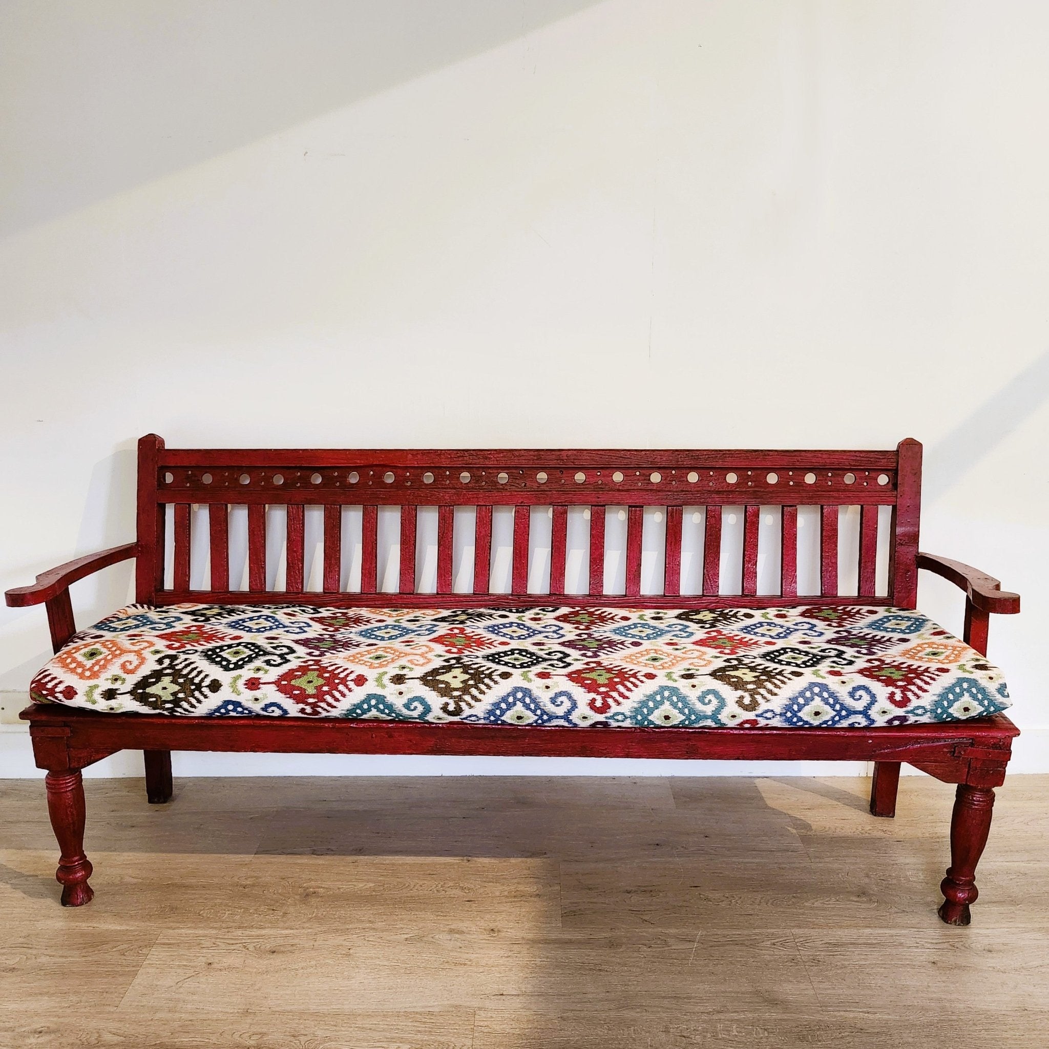 Red painted vintage teak bench, ikat seat cushion, styled