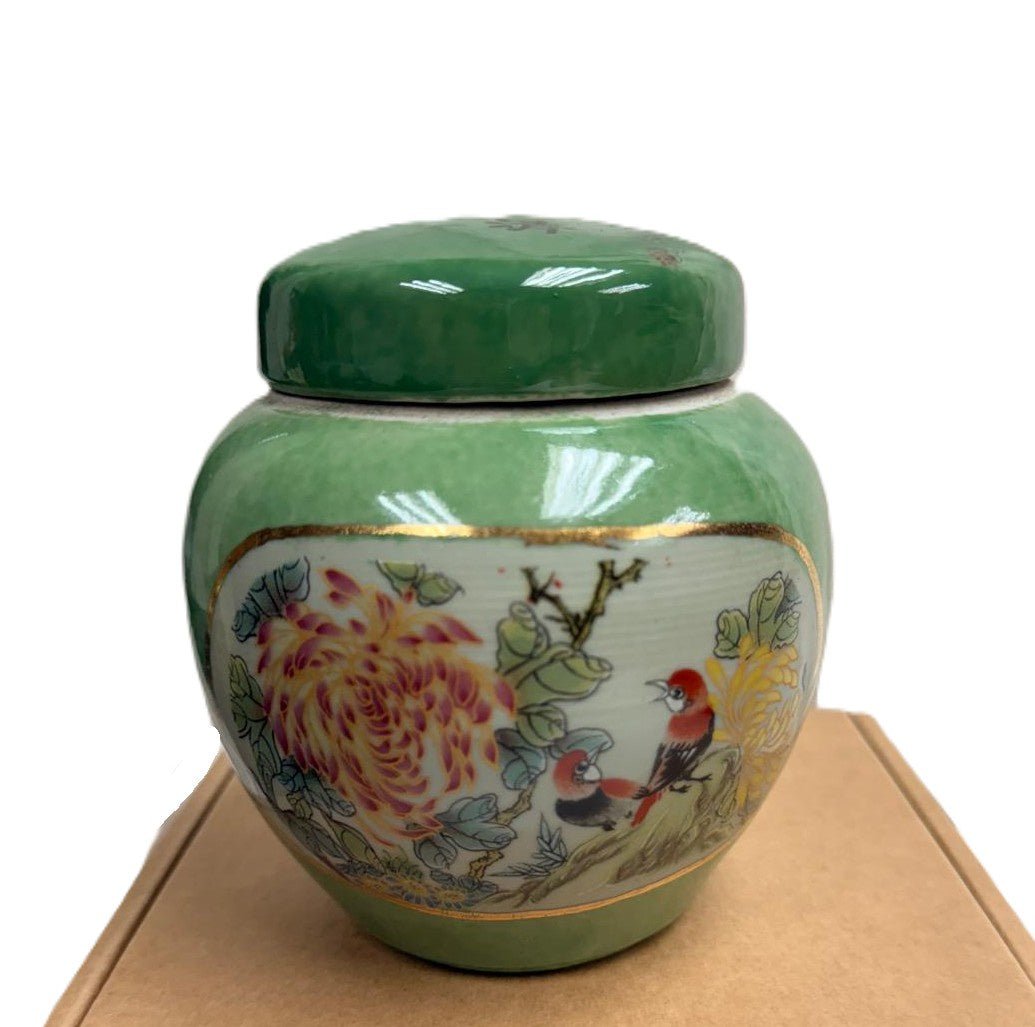 Birds and Flowers candle, green lidded ceramic jar, styled view