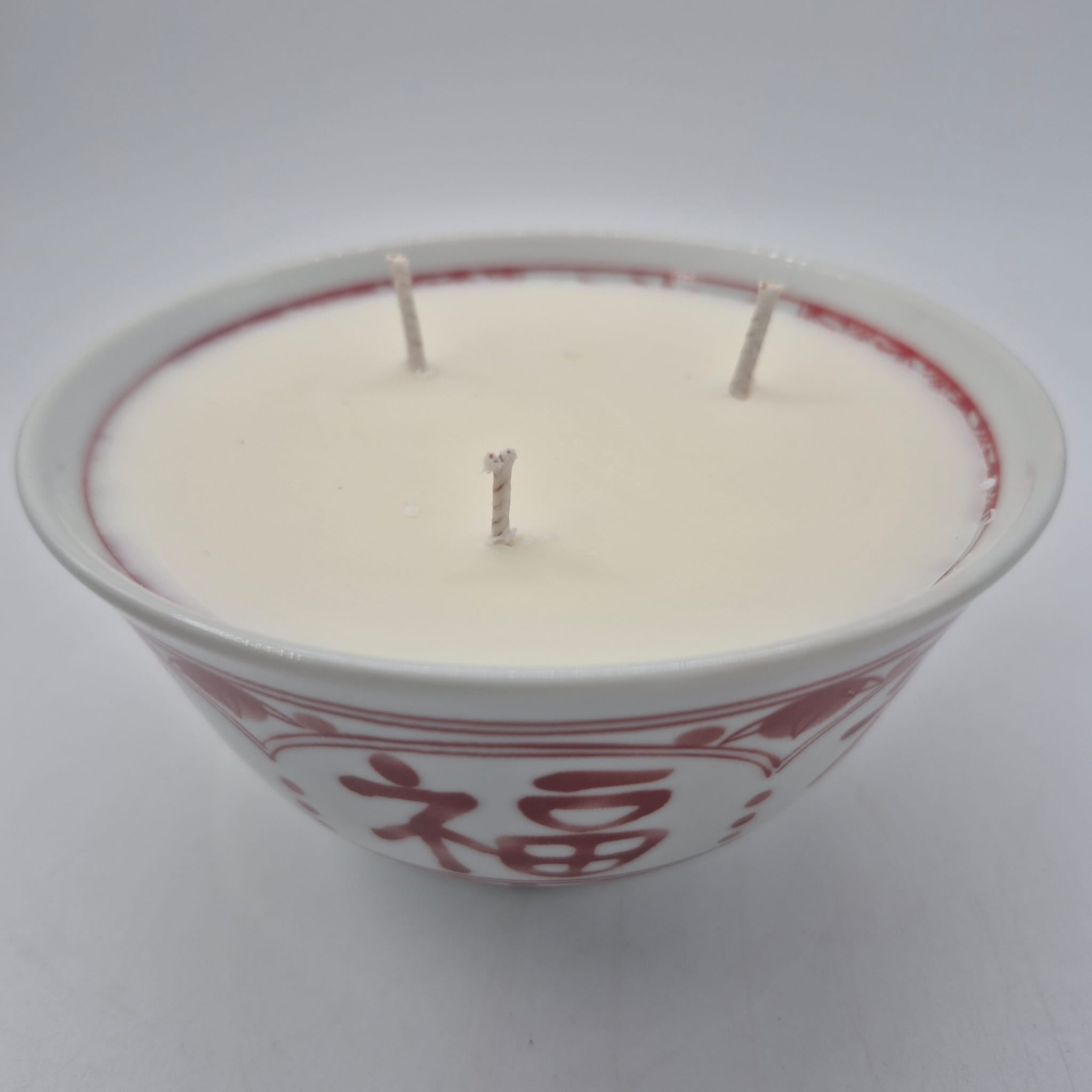 Luck candle, red character on ceramic bowl, three wicks, detail