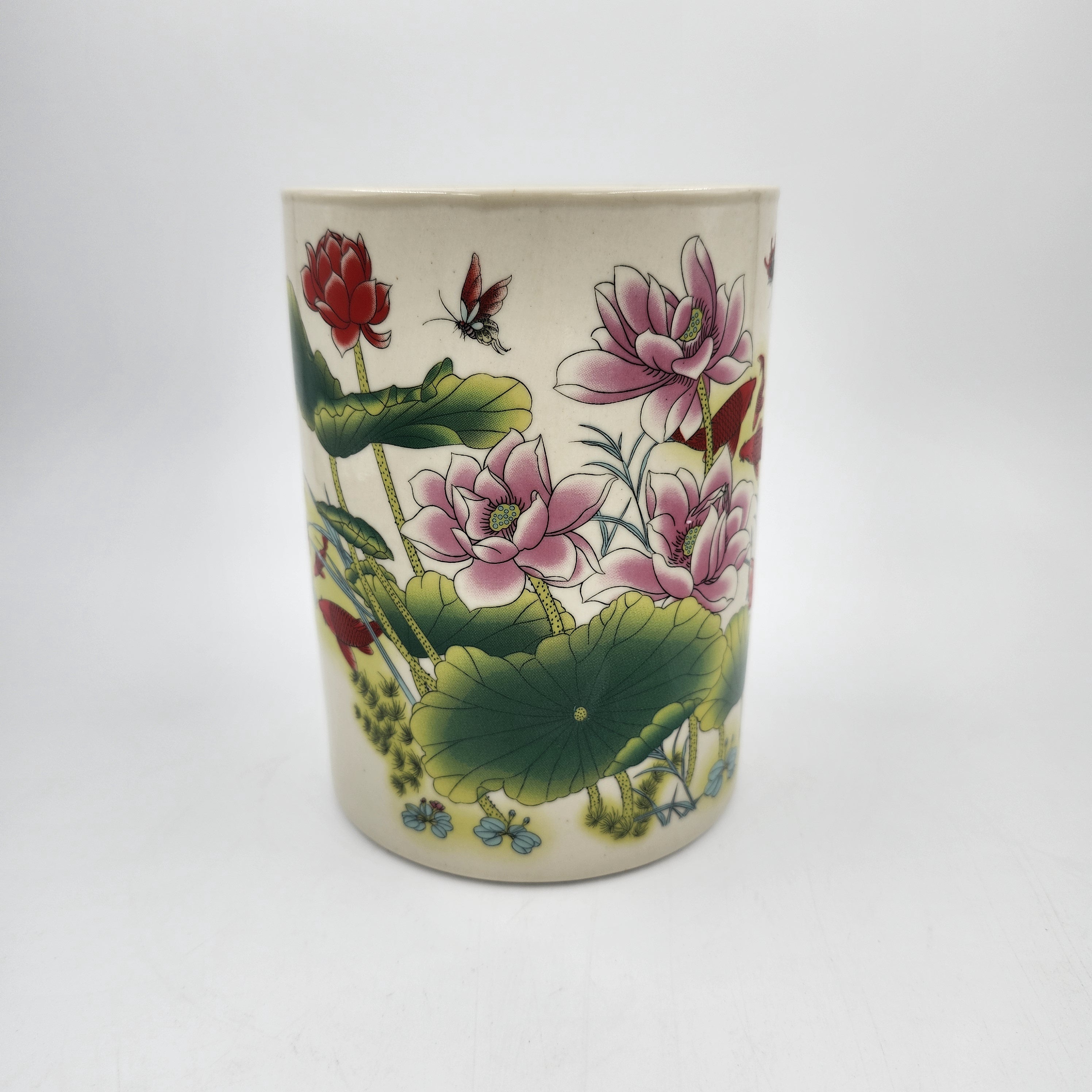 Scented candle in a ceramic jar with lotus design on a white background
