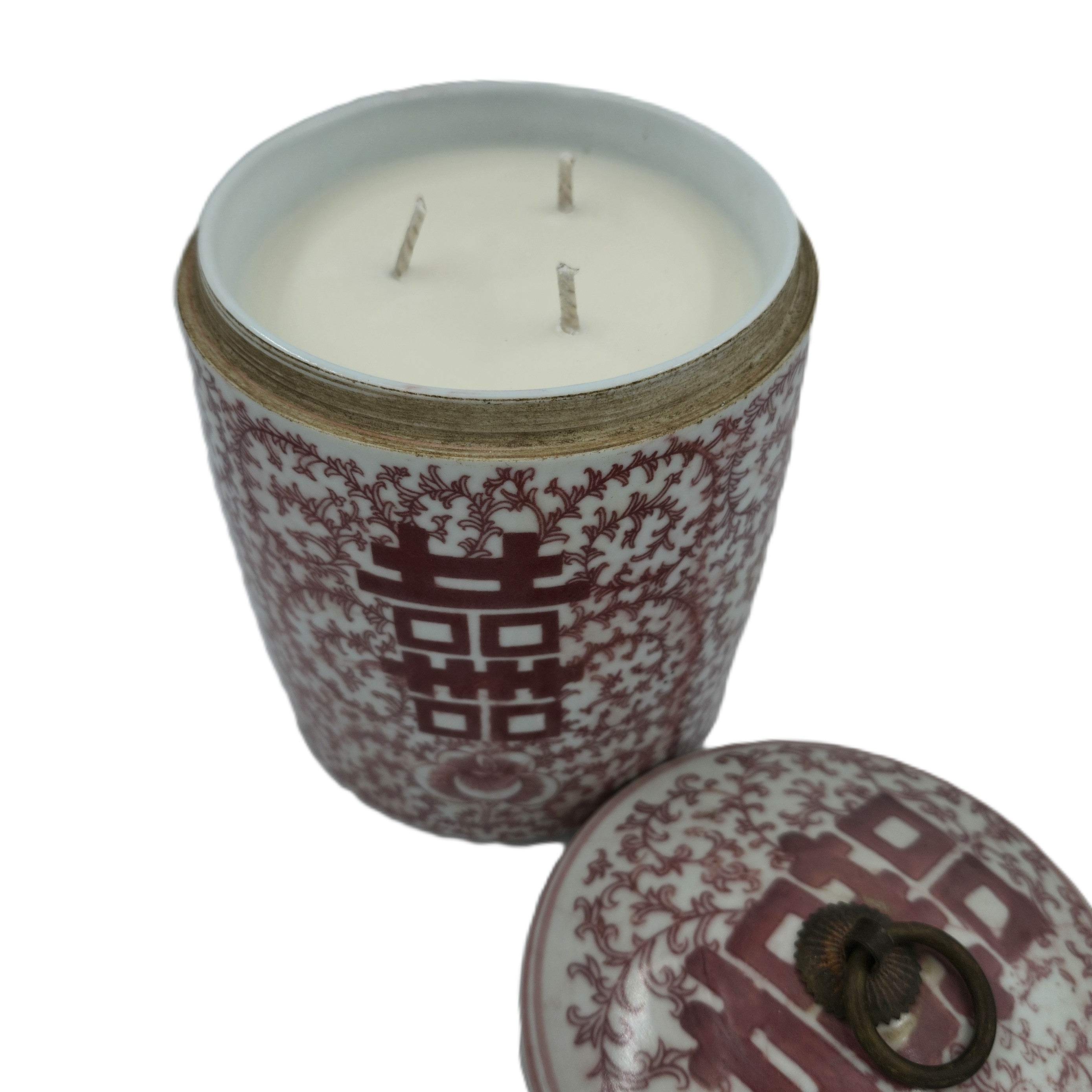Scented candle in a decorative container with the double happiness symbol in faded red