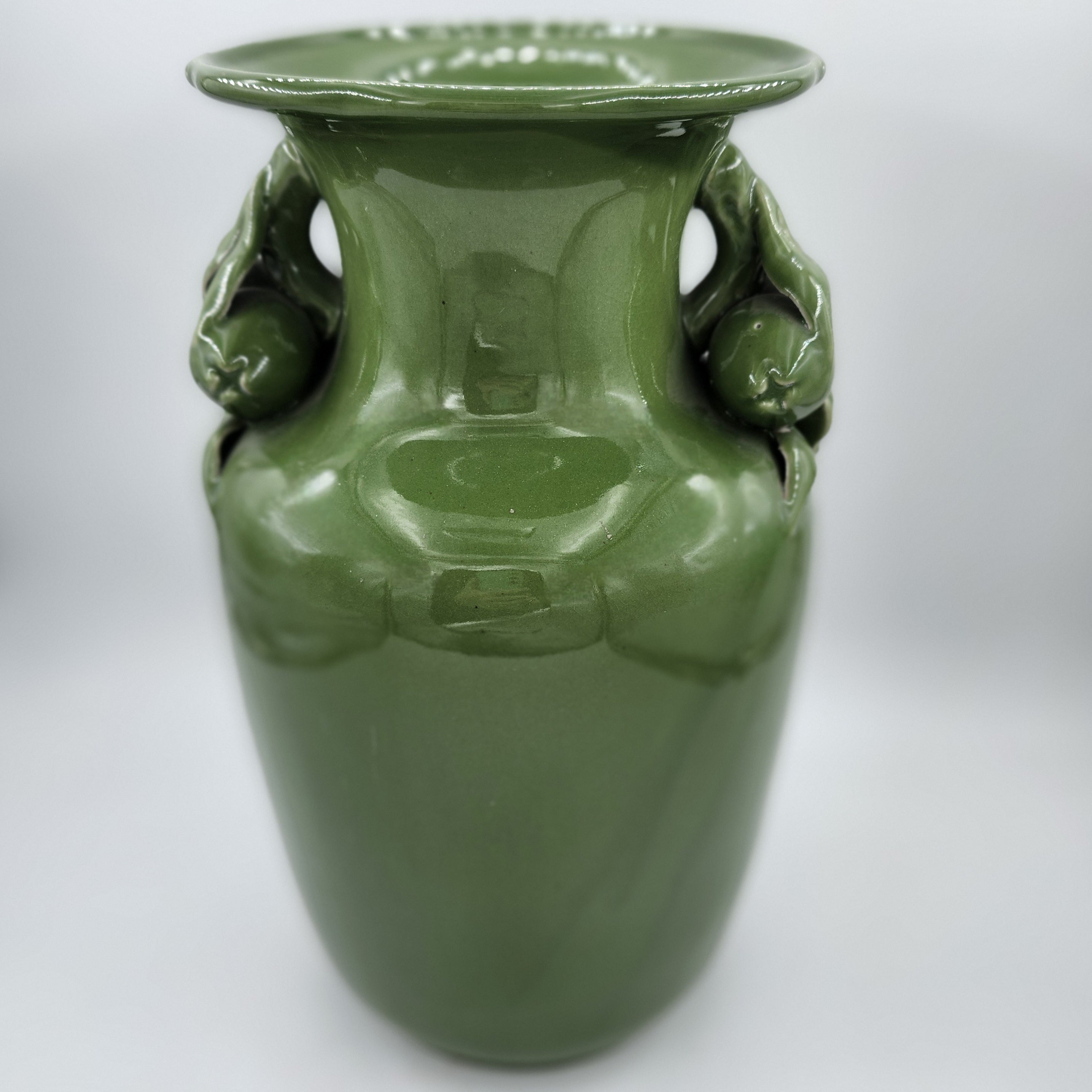 Vintage vase in plain green glaze with fruit and flower neck detail, 32cm high