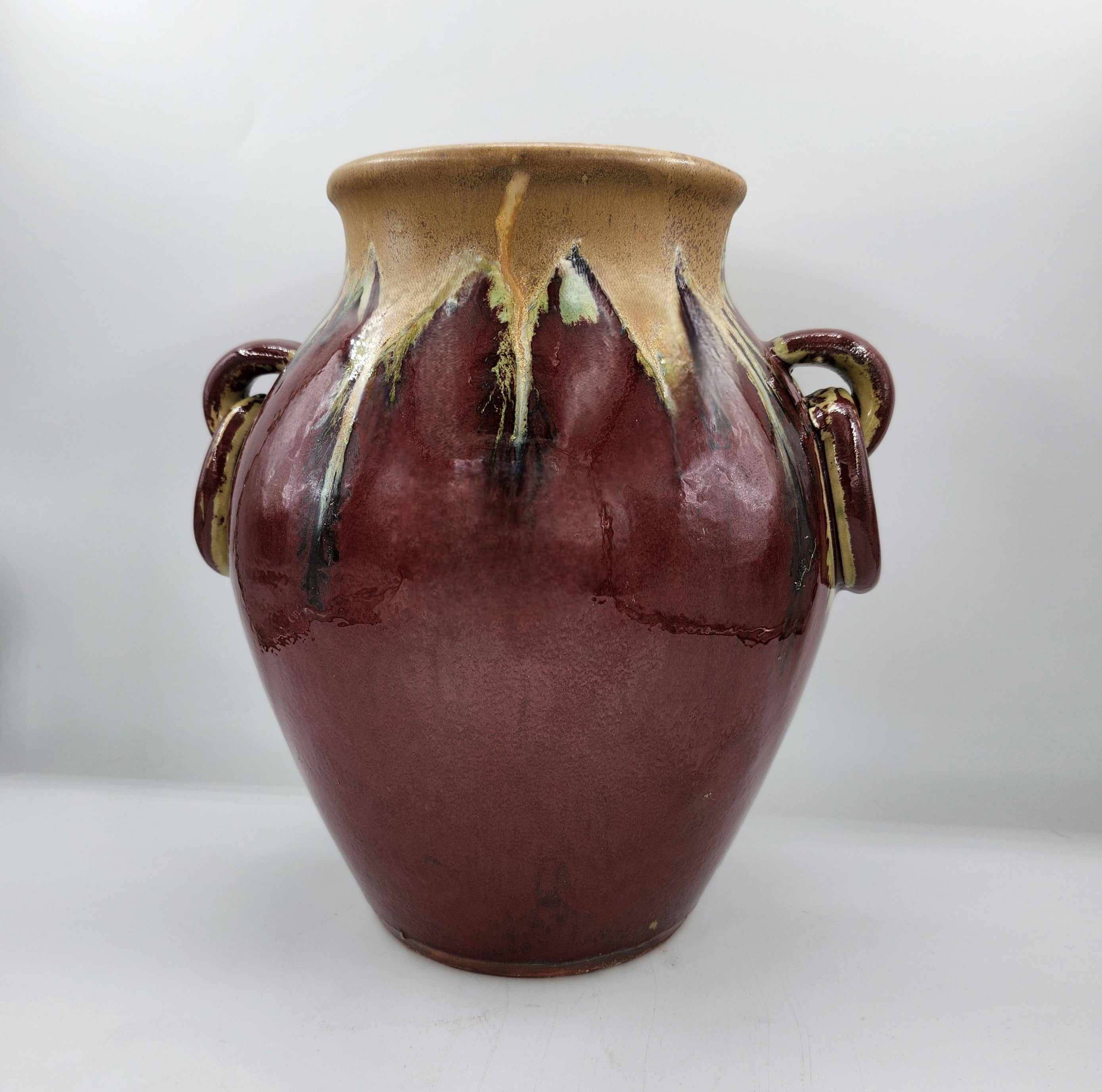 Deep red glazed ceramic lidded pot with two handles, detail