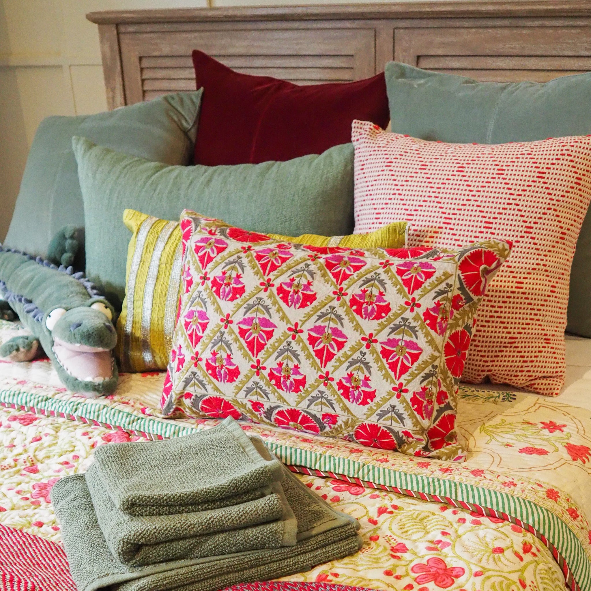Suzani Gulestaan linen cushion in red, dusty pink and green, hand embroidered, 35 x 50cm