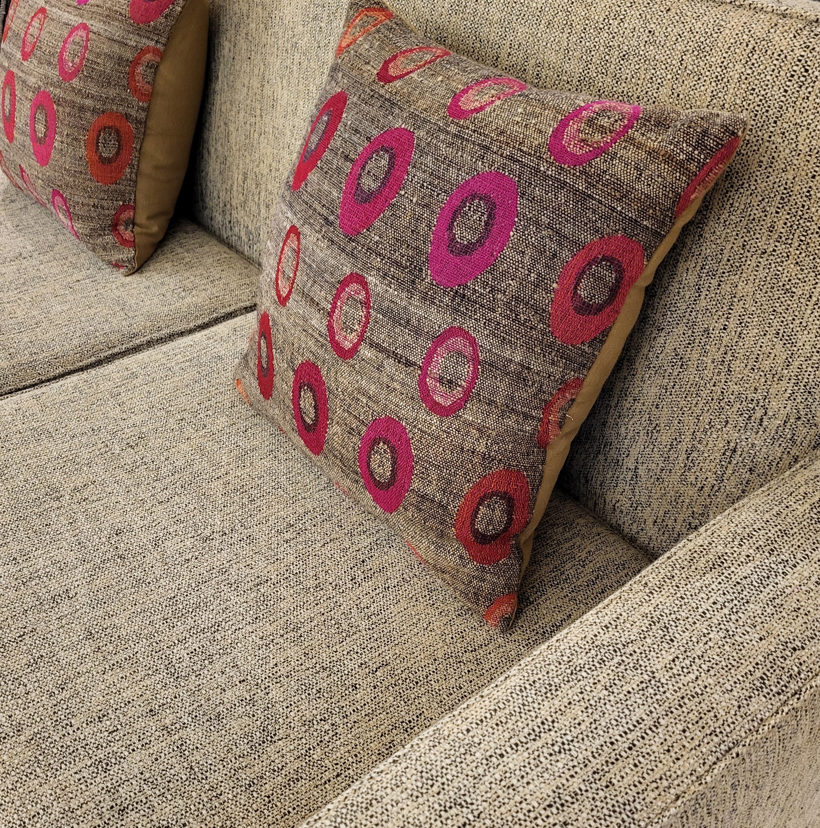 Handwoven O cushion with polka dot pattern styled on a sofa, wool and silk