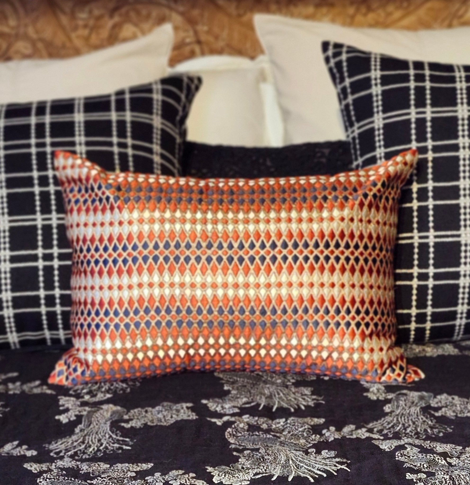 Plaid cushion shown with a red and gold quilt
