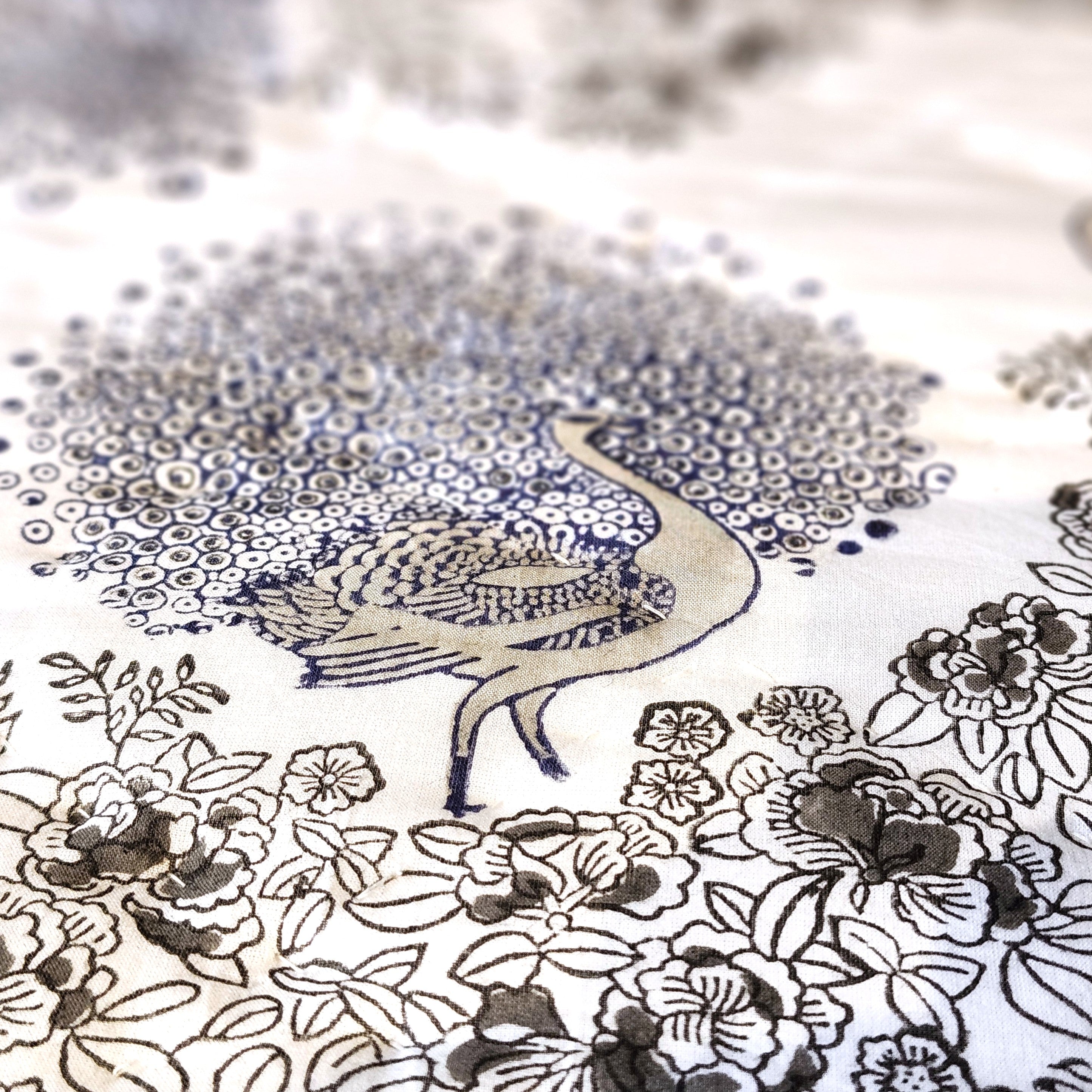 Close-up of blue peacock block print on white voile