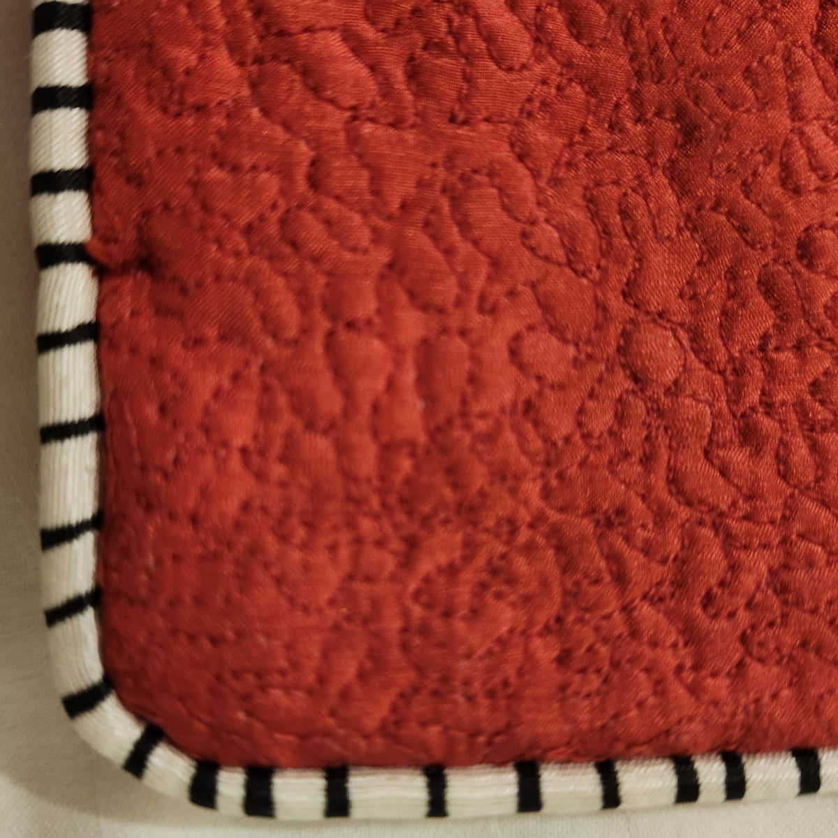 Alternative view of the red silk tiger cushion, showing its delicate quilting and contrast piping.