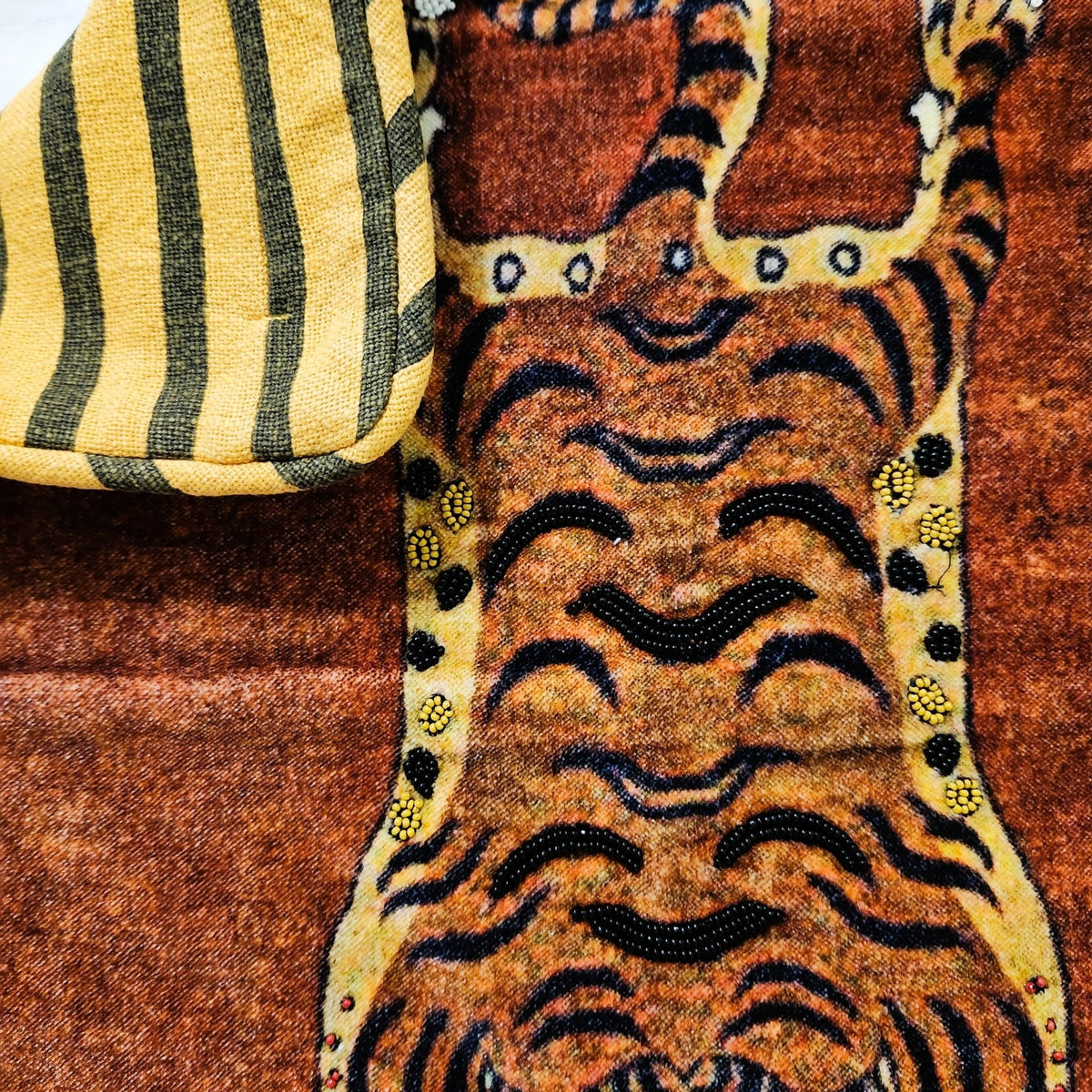 Detail of the beaded tiger figure on the cotton velvet cushion cover, hand crafted in India.