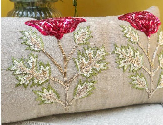 Decorative pillow with floral embroidery and red poppies on a neutral background