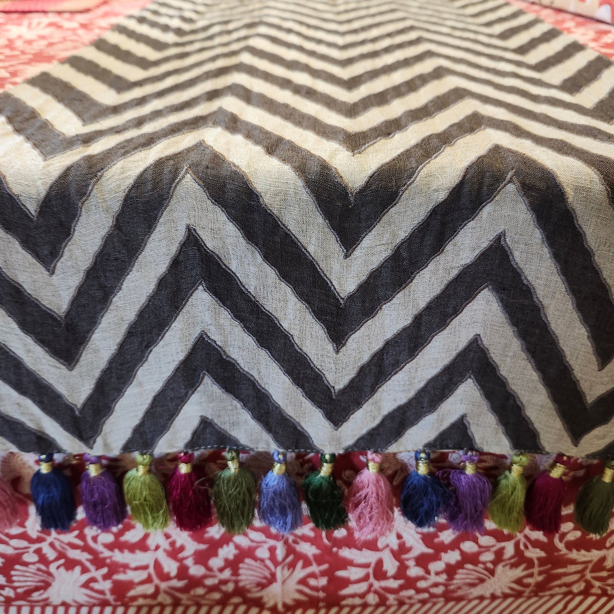 Linen table runner with plain and chocolate chevron stripes stitched together, hand-crafted tassels in several colours