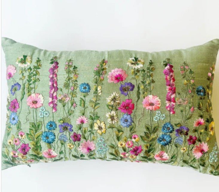 Decorative pillow with floral pattern on a green raw silk background