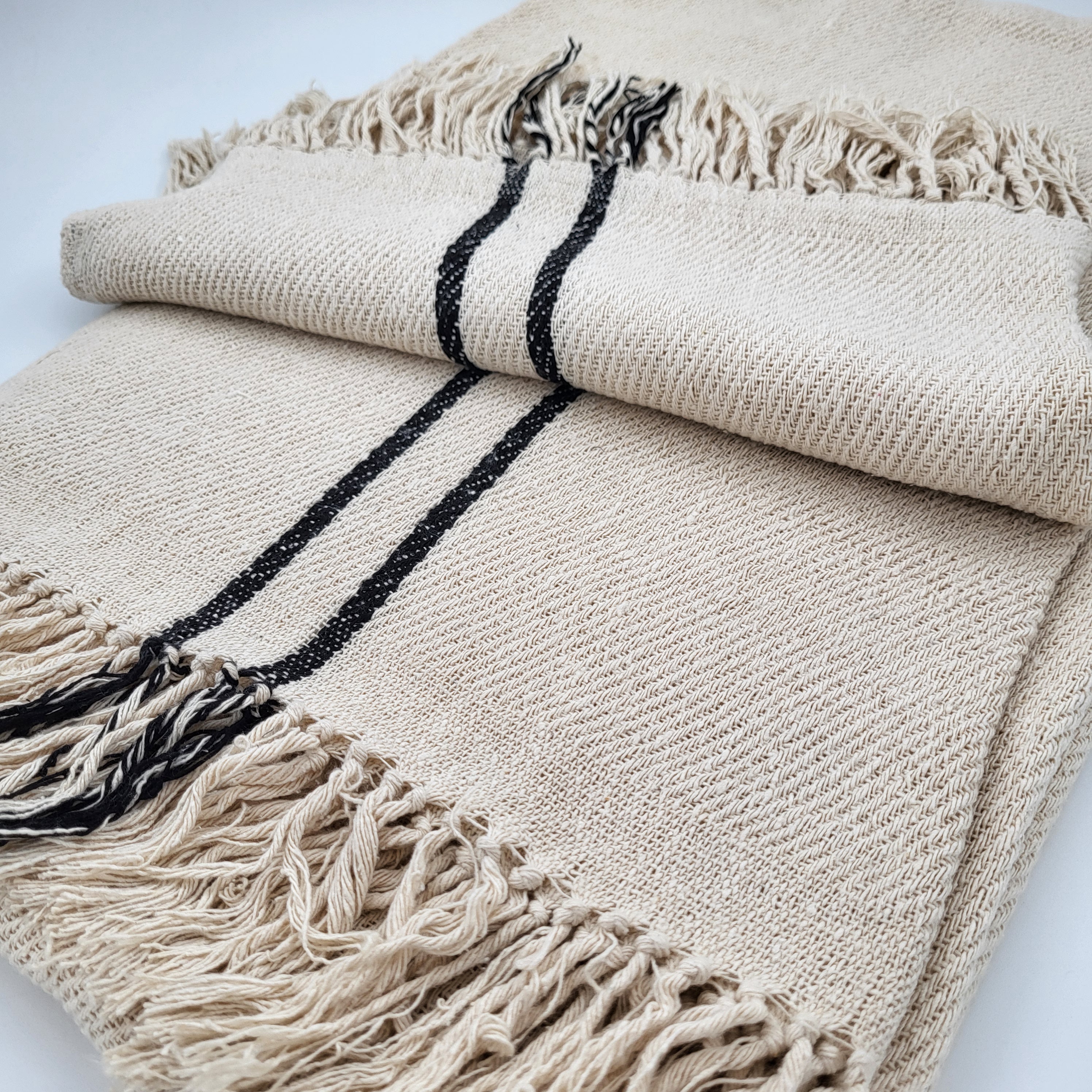 Handwoven cream silk throw with black parallel line edges and fringing, 130 x 200 cm