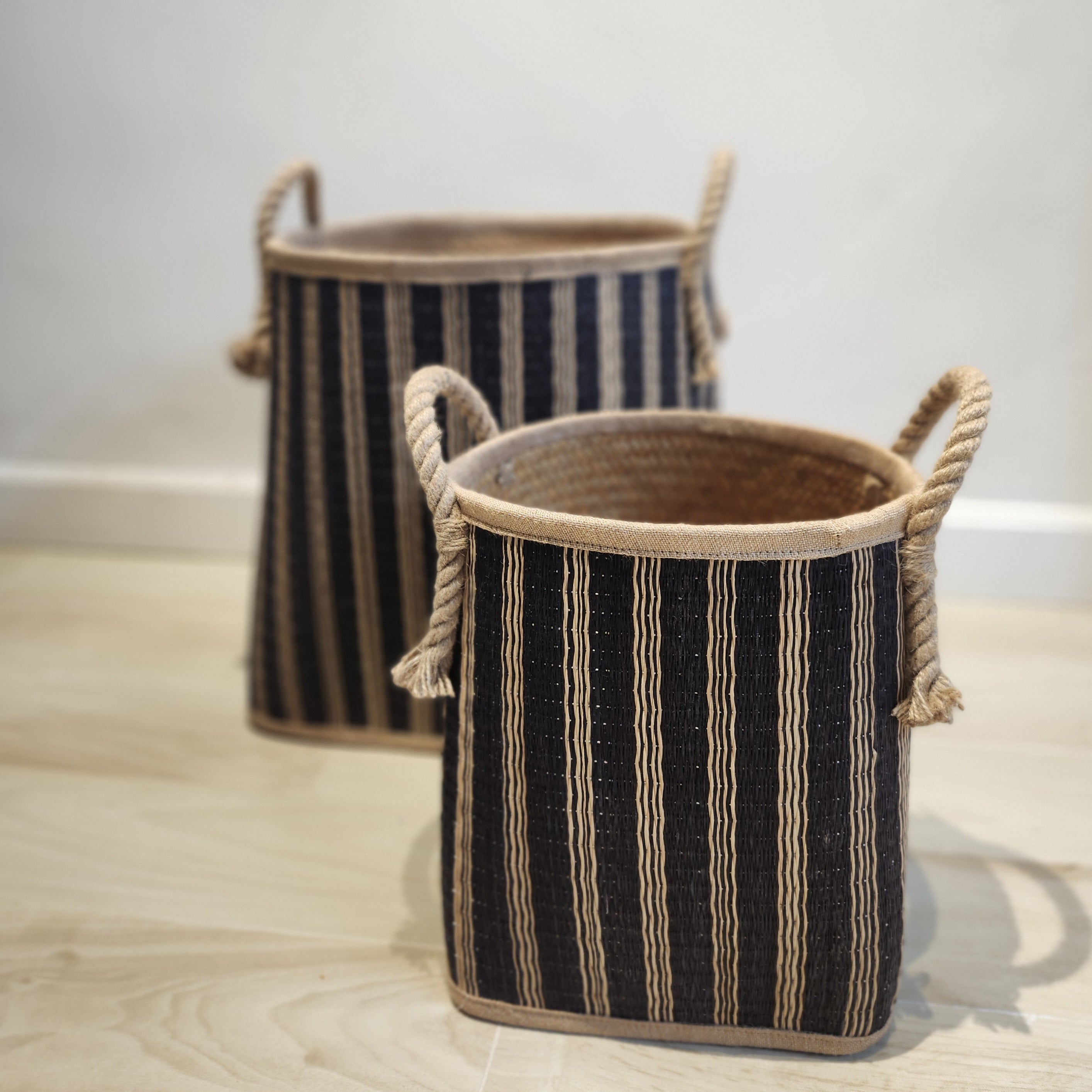 Wicker laundry basket with a dark blue stripe and rope handles