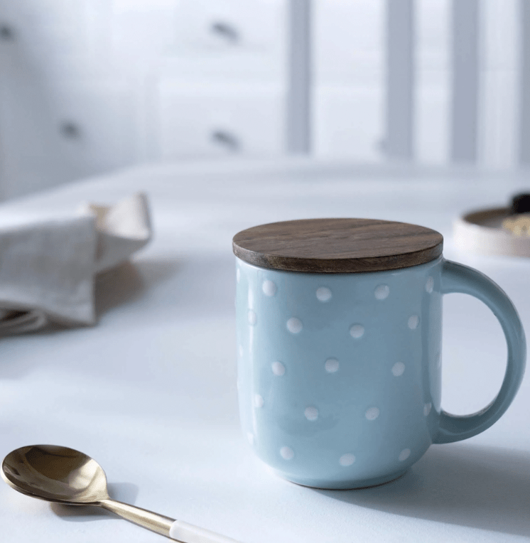Blue polka-dot ceramic mug with a wooden lid coaster