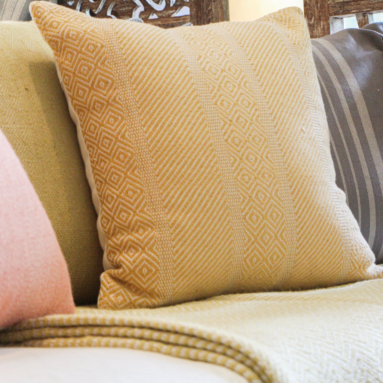 Gold Minerva woven cushion by Weaver Green, styled in a room